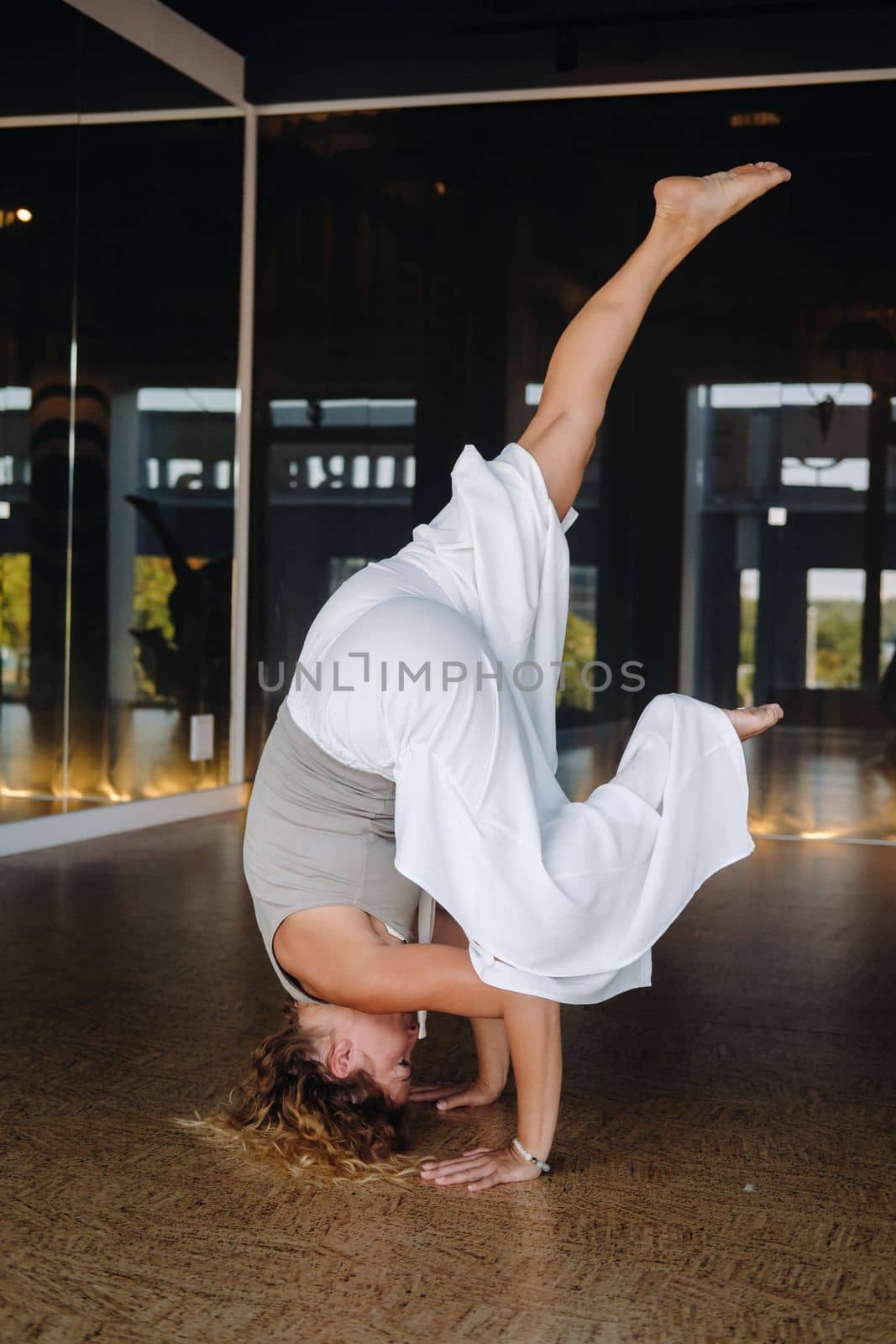 A woman Performing yoga exercises on her head in the gym.