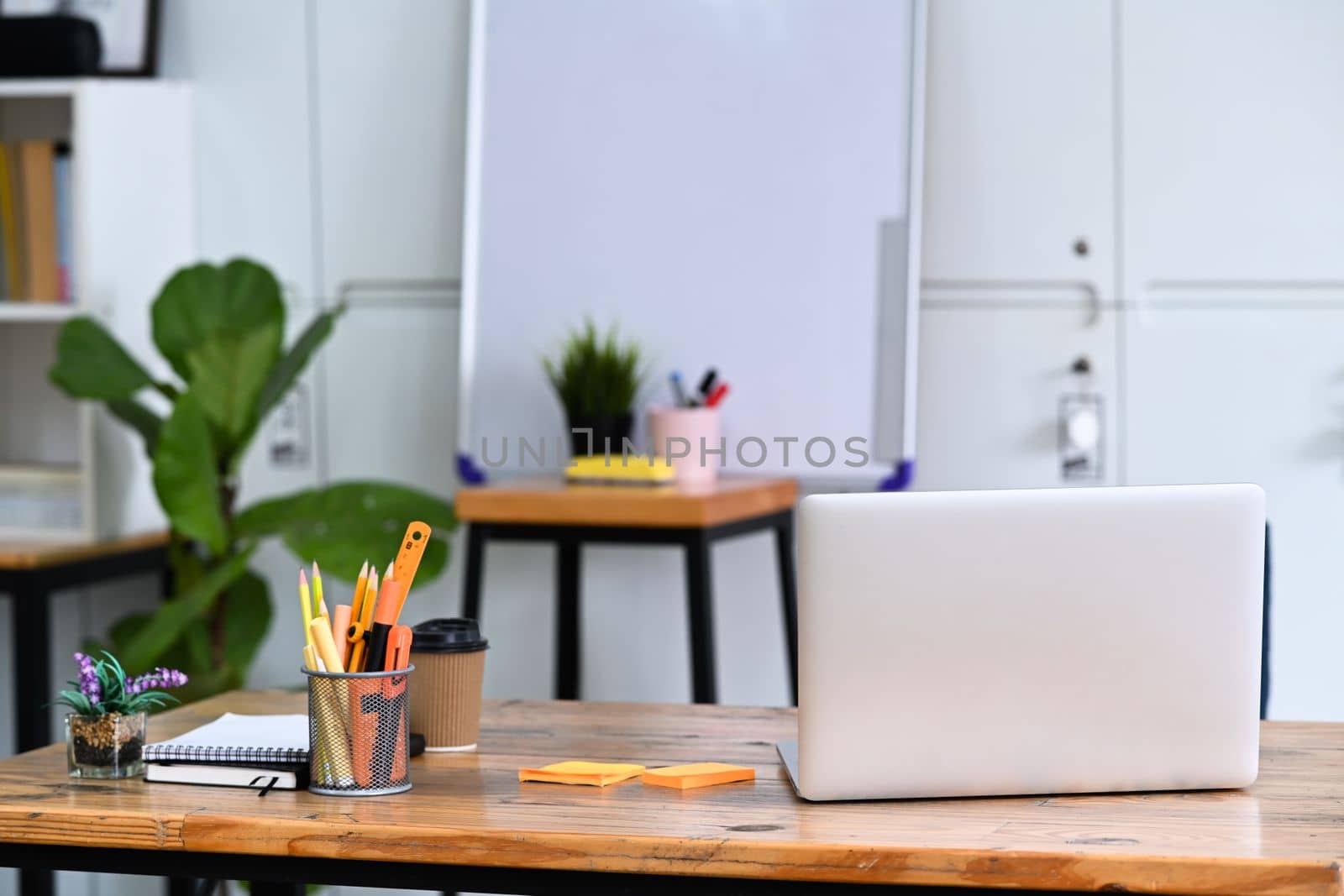 Computer laptop and office supplies on wooden office desk. by prathanchorruangsak