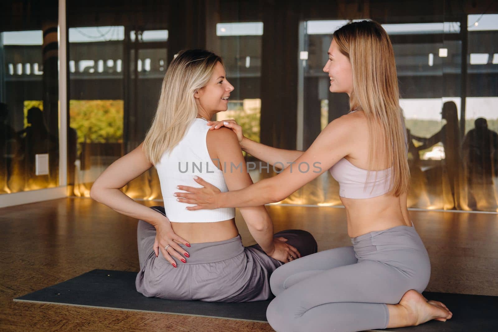 Yoga exercises. A personal trainer teaches a woman yoga classes in the gym.