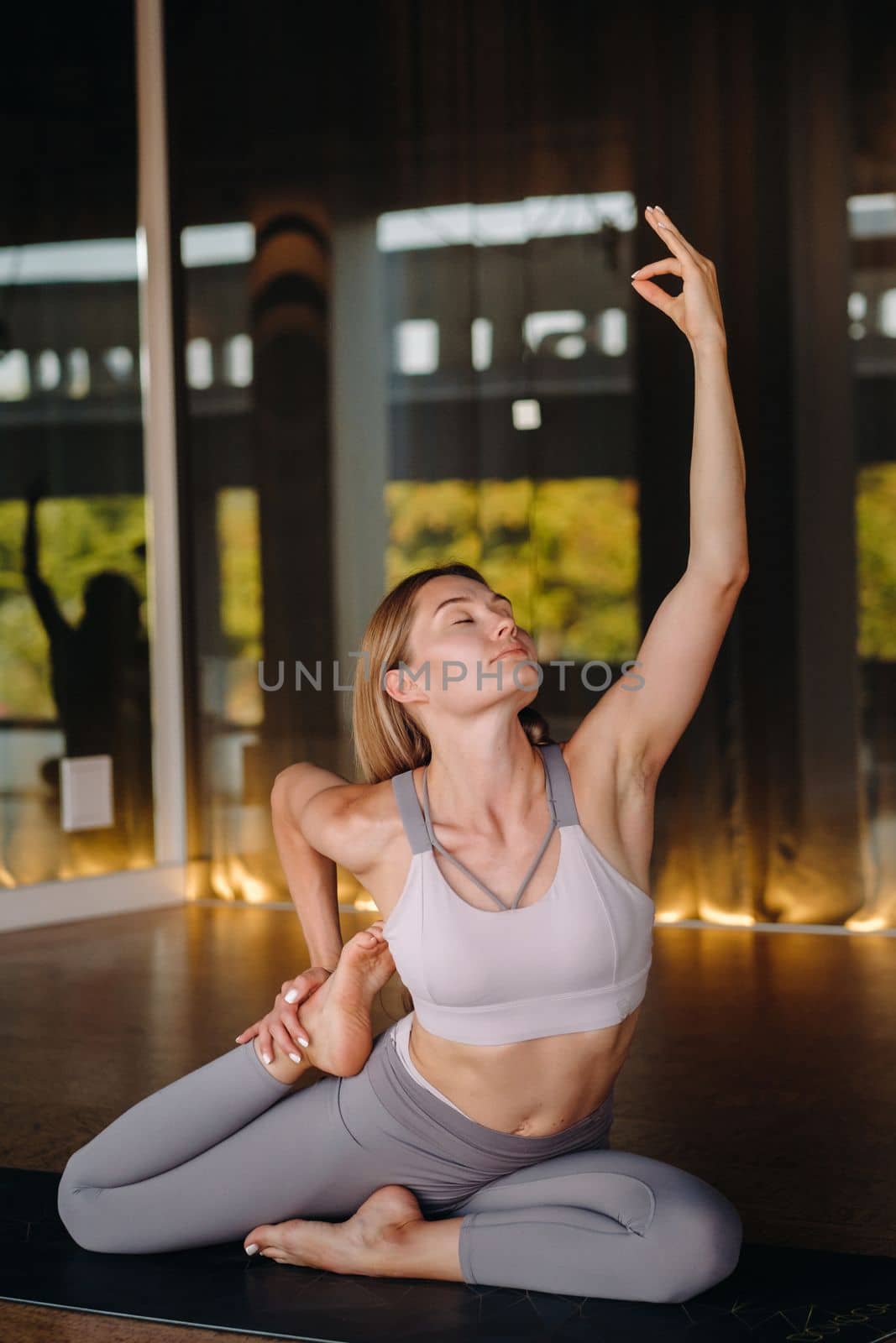 The girl does yoga. A woman in sports clothes does yoga exercises in the gym.