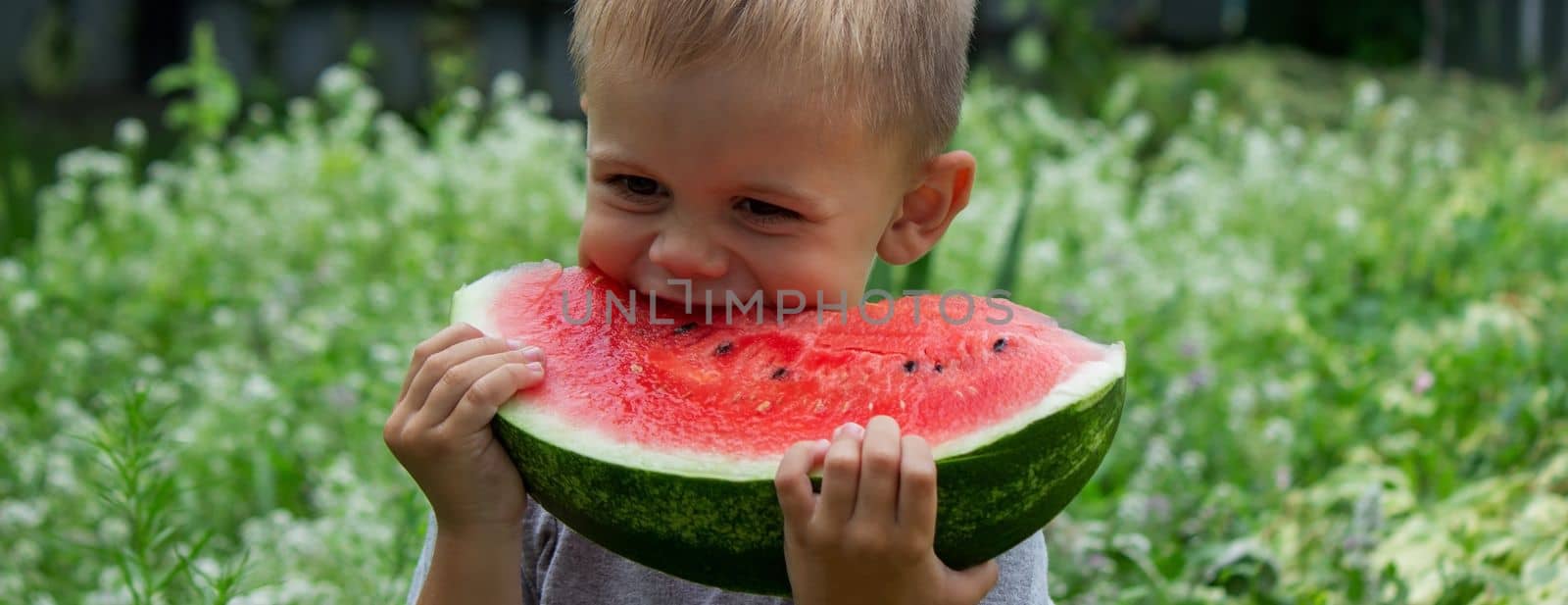 A child eats a watermelon. Selective focus. Nature