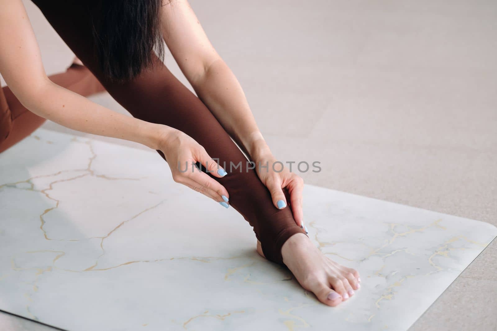 close-up of the legs and arms of a girl who does yoga in a fitness room. Healthy lifestyle, fitness, training, self-care by Lobachad