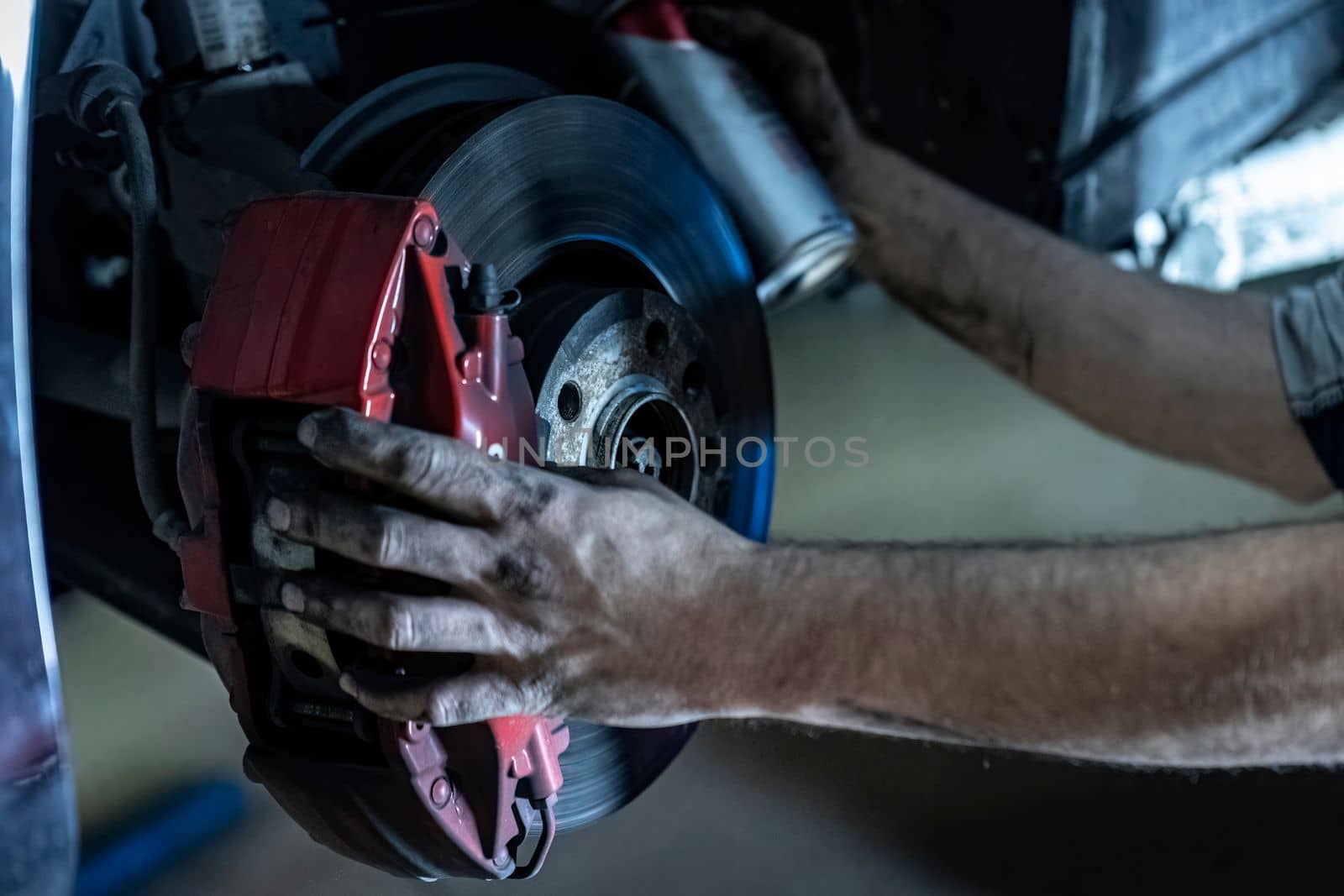 Mechanic hands detail during a maintenance of car brakes