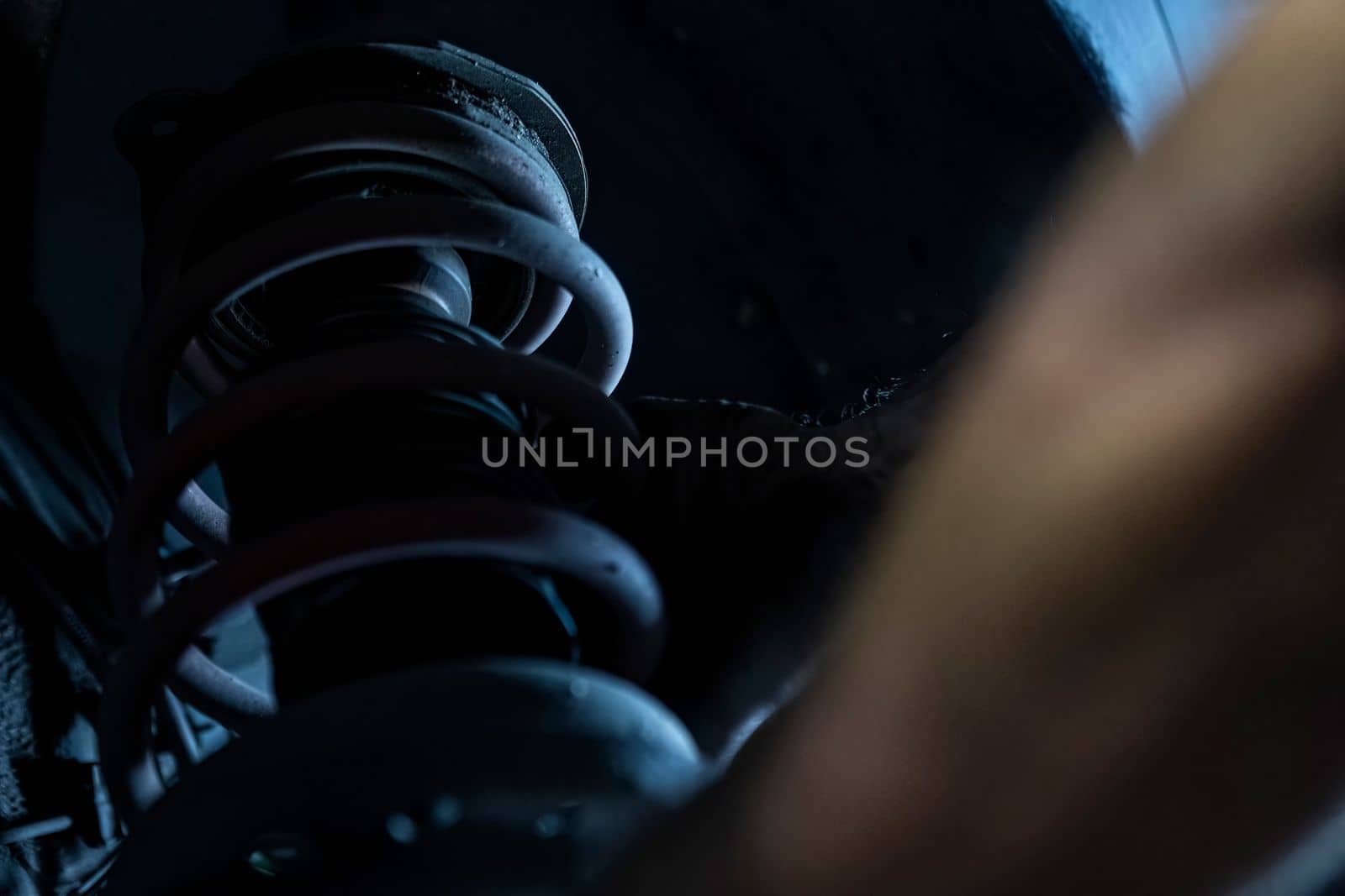 Mechanic hands detail during a maintenance of car suspension