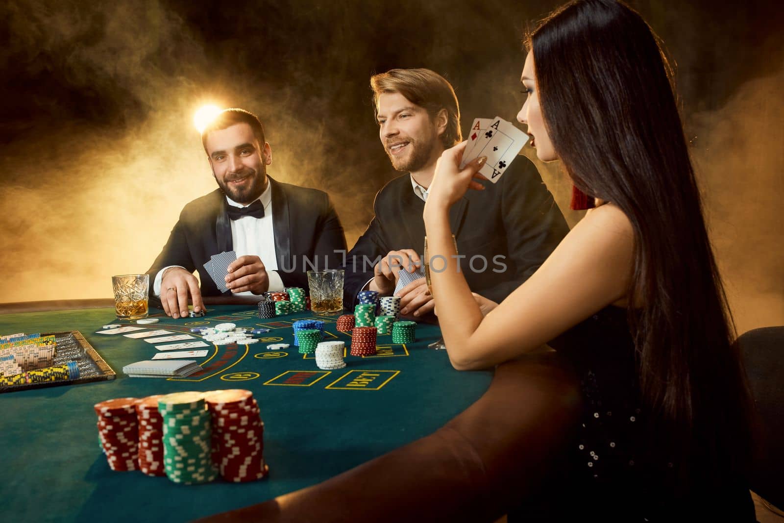 Group of young rich people is playing poker in the casino by nazarovsergey