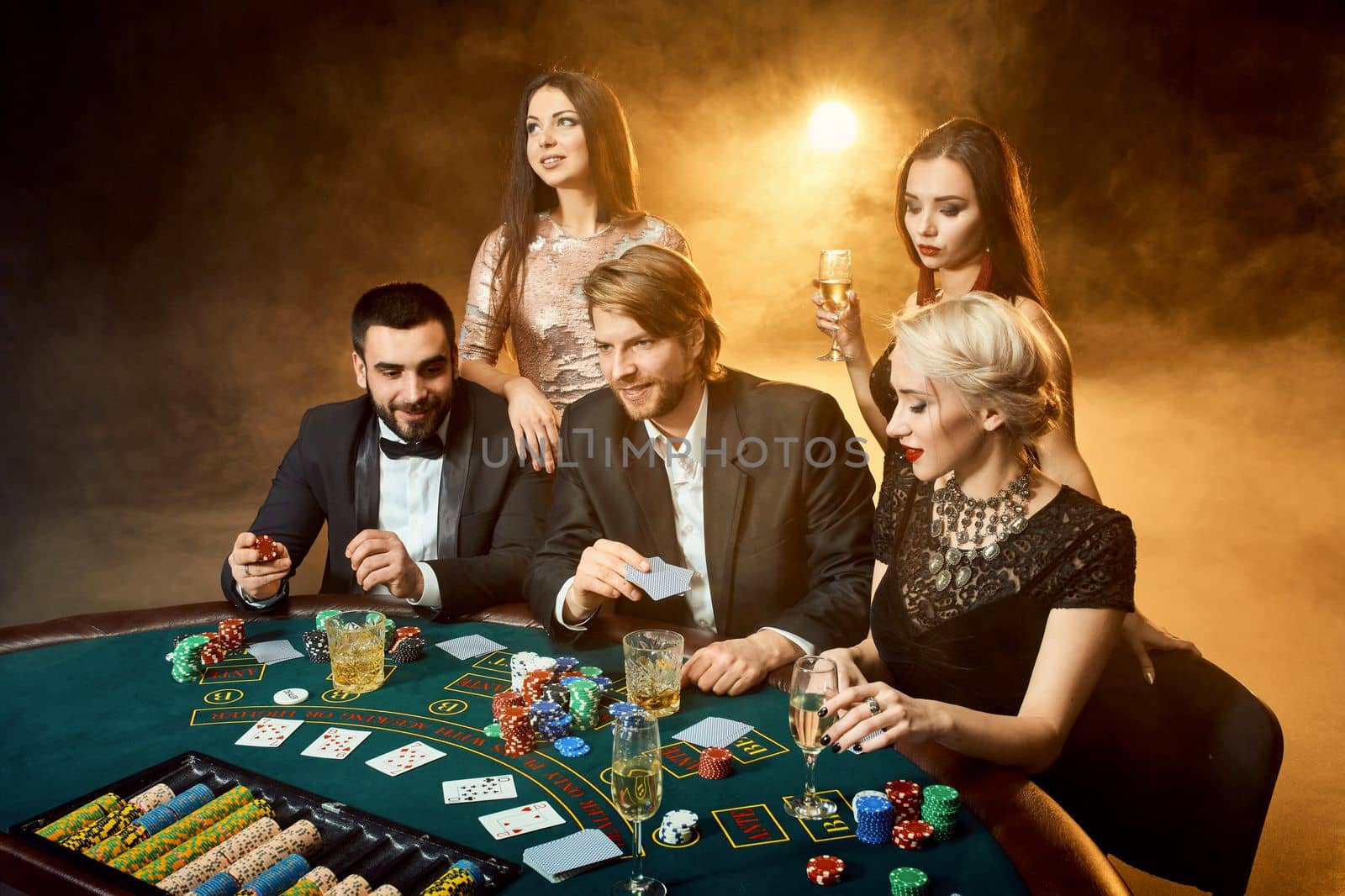 Poker players sitting around a table at a casino. by nazarovsergey