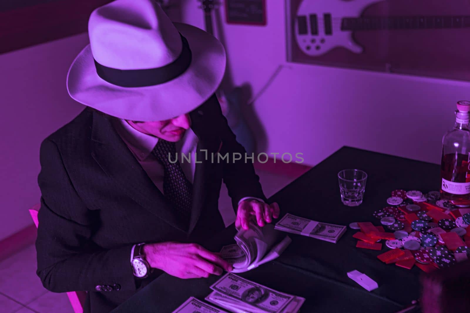 Mans hands place stacks of dollars into briefcase getting ready for a poker game by pippocarlot