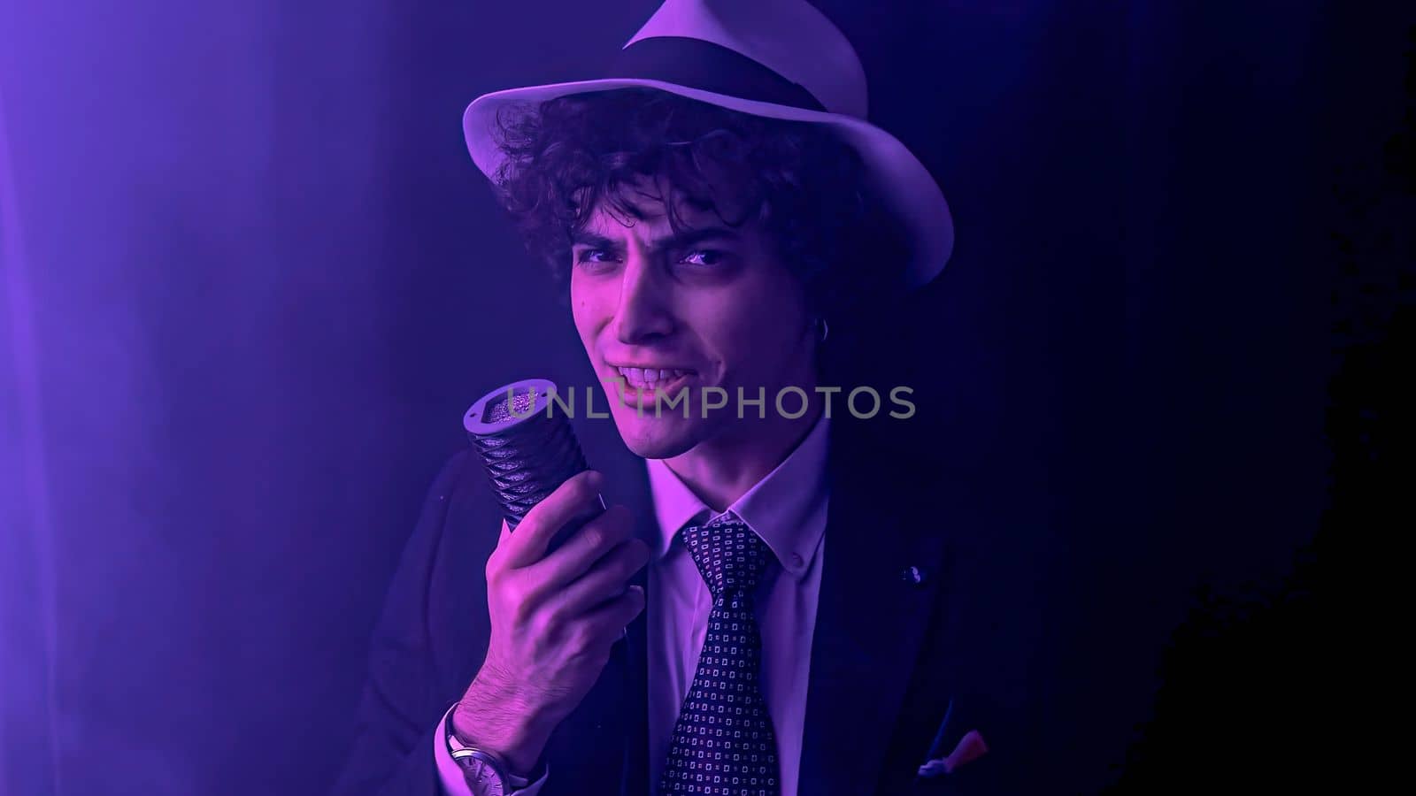 A playful and energetic young man singing a song. With a microphone in hand and a mischievous twinkle in his eye. Talented performer with his infectious energy and hilarious facial expressions.