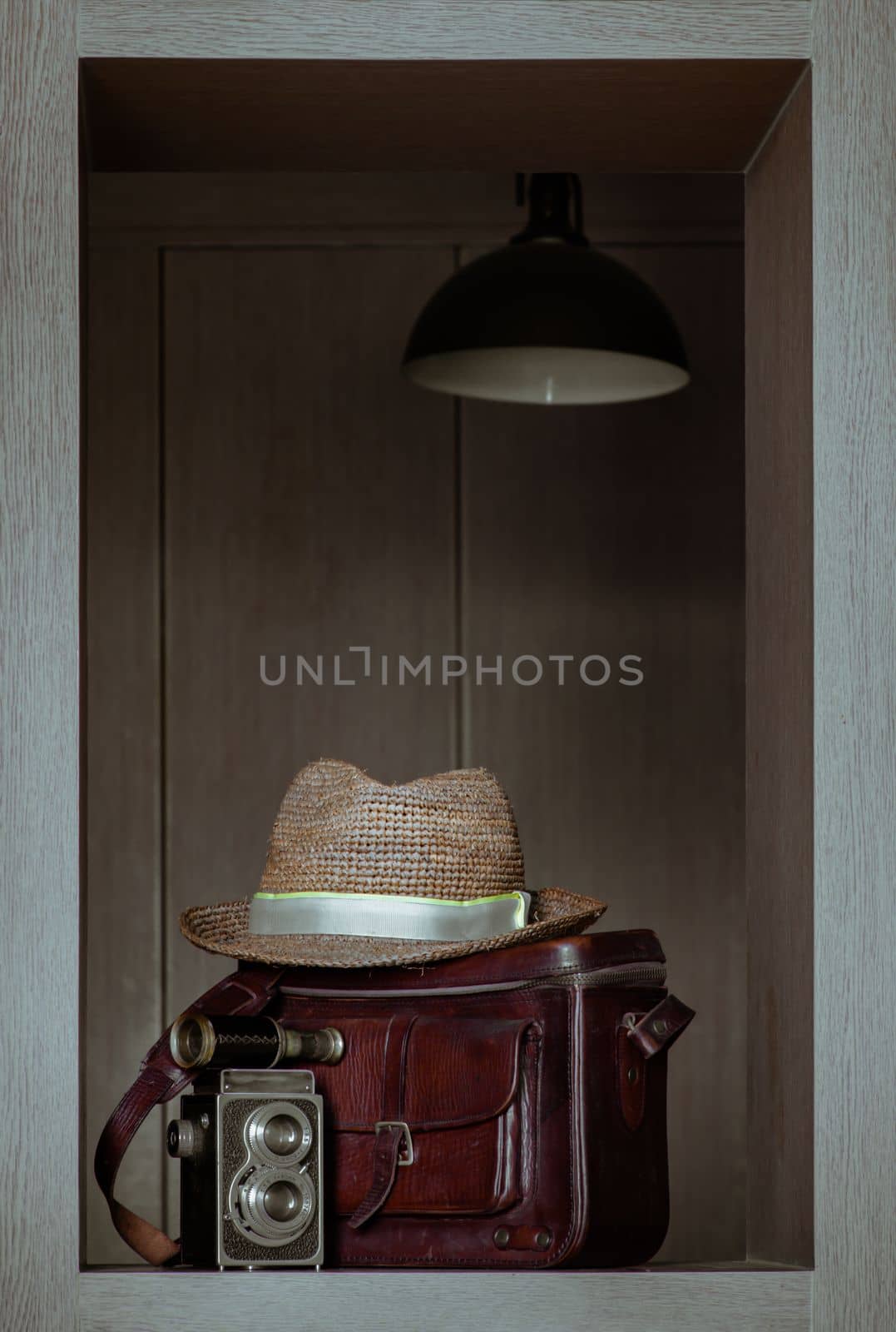 Vintage binocular on Vintage two lens photo camera front of Straw fedora hat on Vintage brown leather bag. by tosirikul