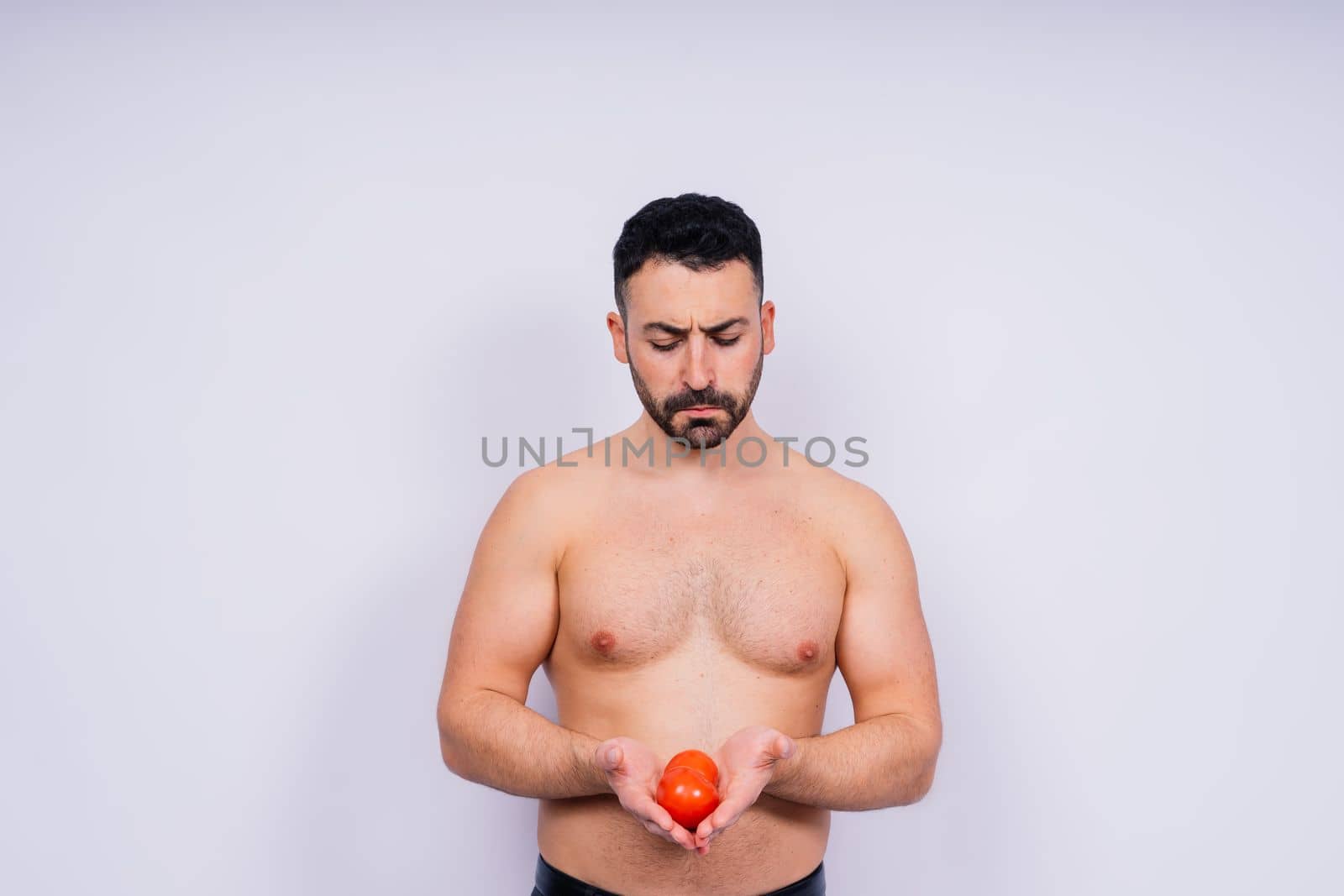 Full isolated studio picture from a young naked man with underwear and tomato by Zelenin