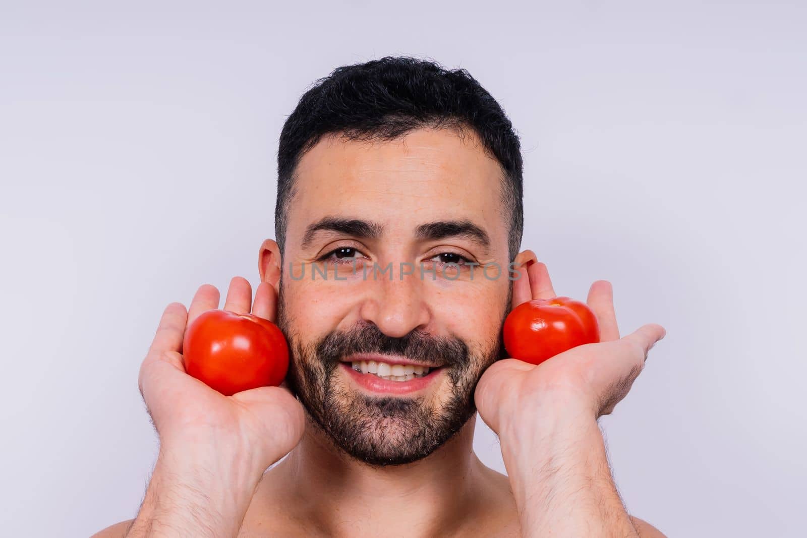 Full isolated studio picture from a young naked man with underwear and tomatoes