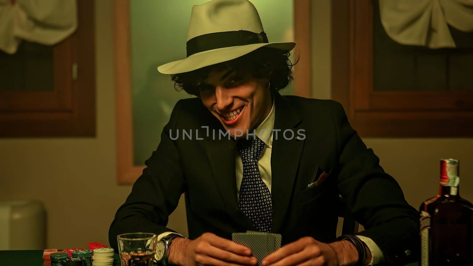An intense shot of a poker player with cards in hand. He confidently laying them down on the table. The player's facial expression, conveying a sense of cunning and deception.