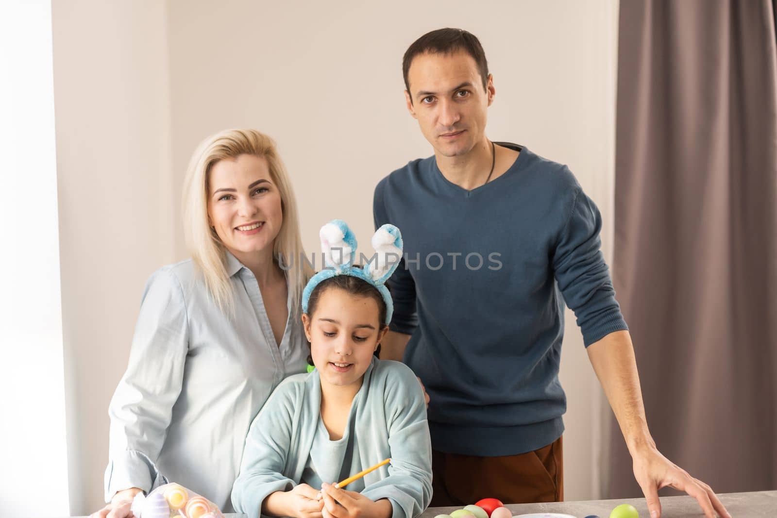 Nice lovely sweet attractive beautiful friendly cheerful positive family paining Easter eggs together