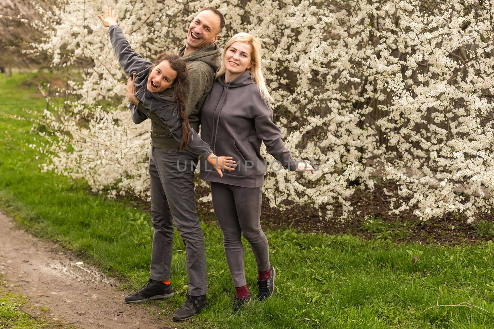 family in blooming garden with trees