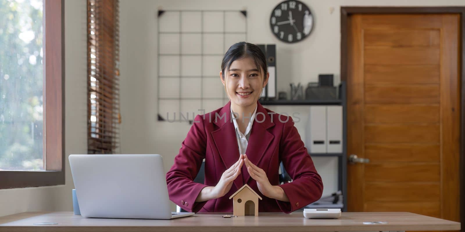 Real estate concept, charming business woman holding a house model. Property insurance and security concept. Protecting gesture of female and symbol of house. by nateemee