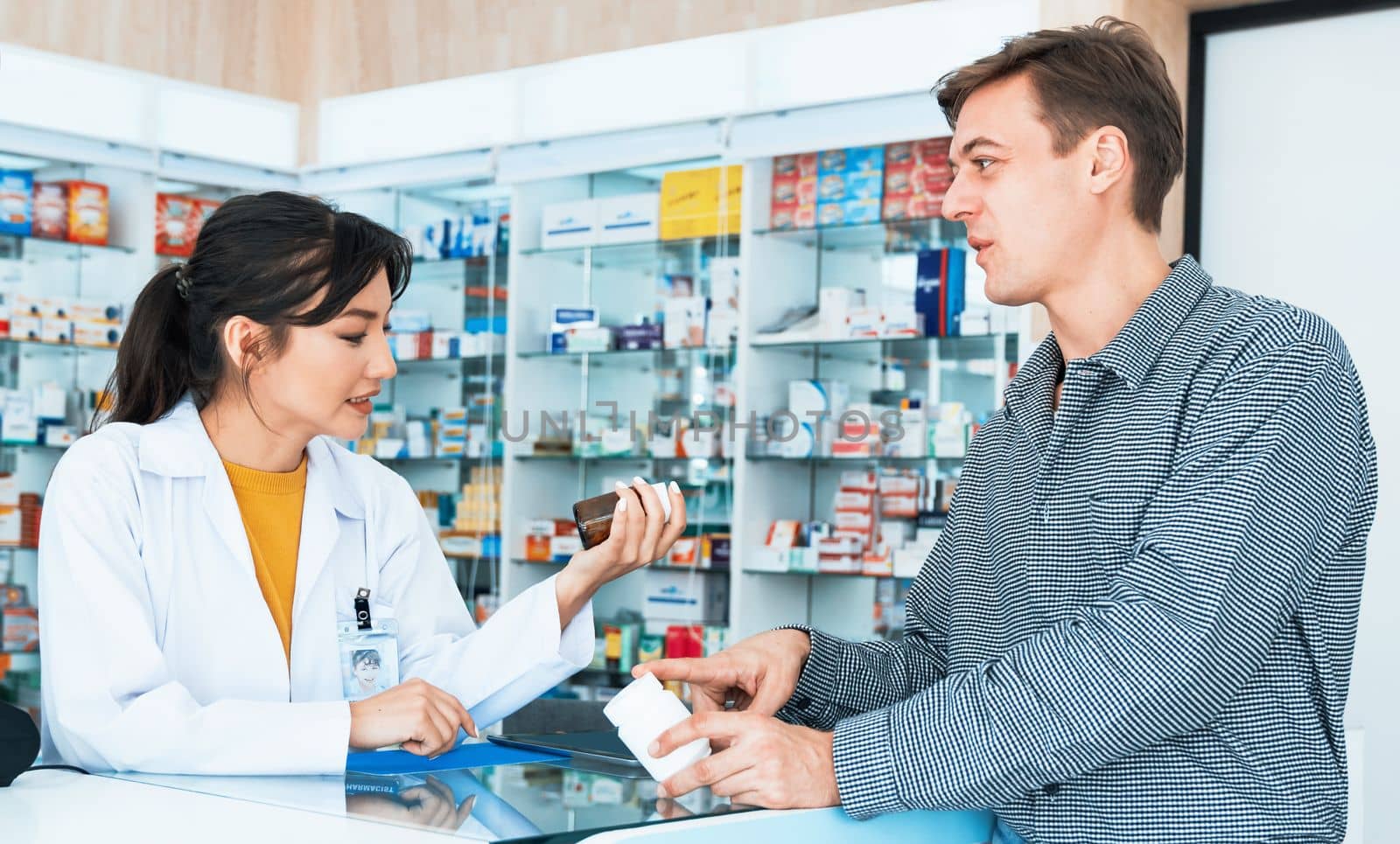 Professional pharmacist advise or explain property of qualified medical product to customer in pharmacy, druggist answer to client healthcare inquiry, medical service and consultation concept.