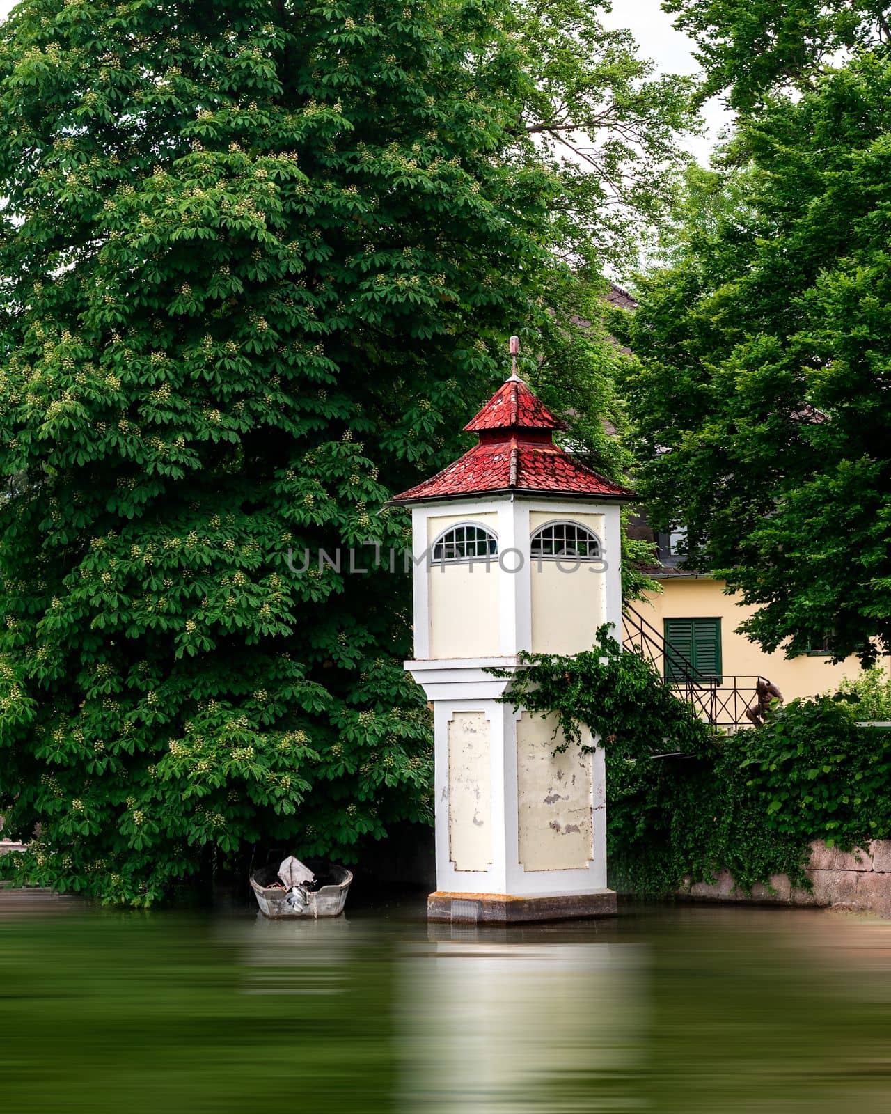 Historical tower building and a boat in the lake by Millenn