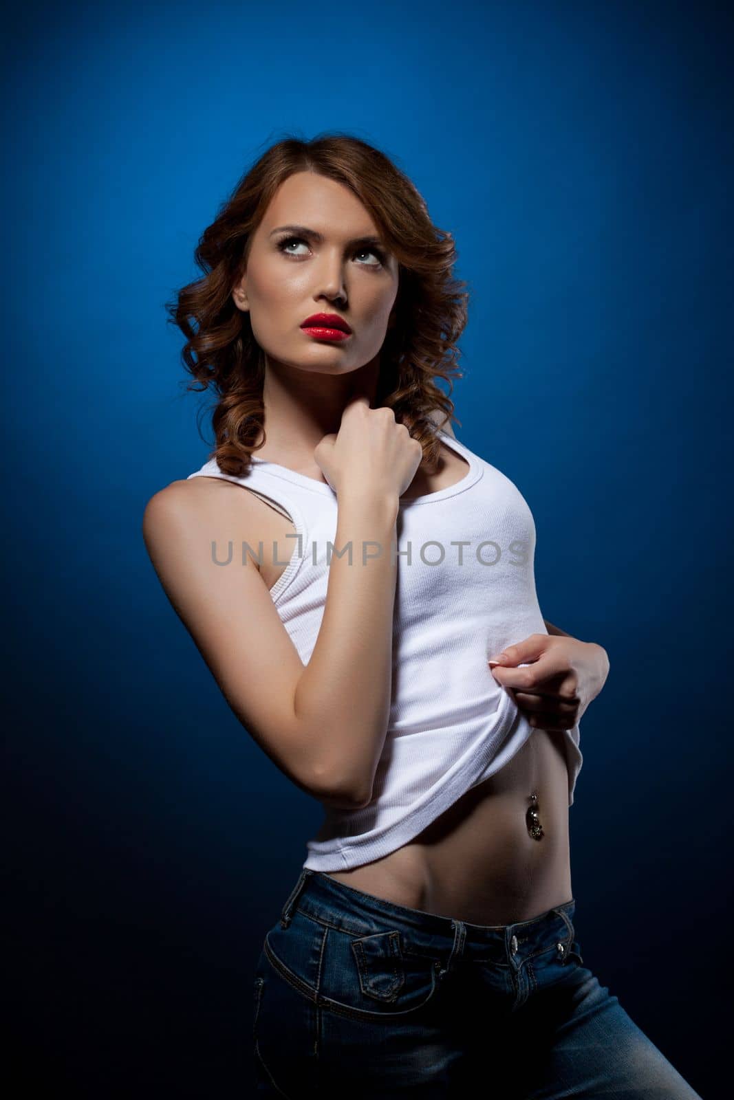 Young beautiful brunette woman in jeans and white tank top