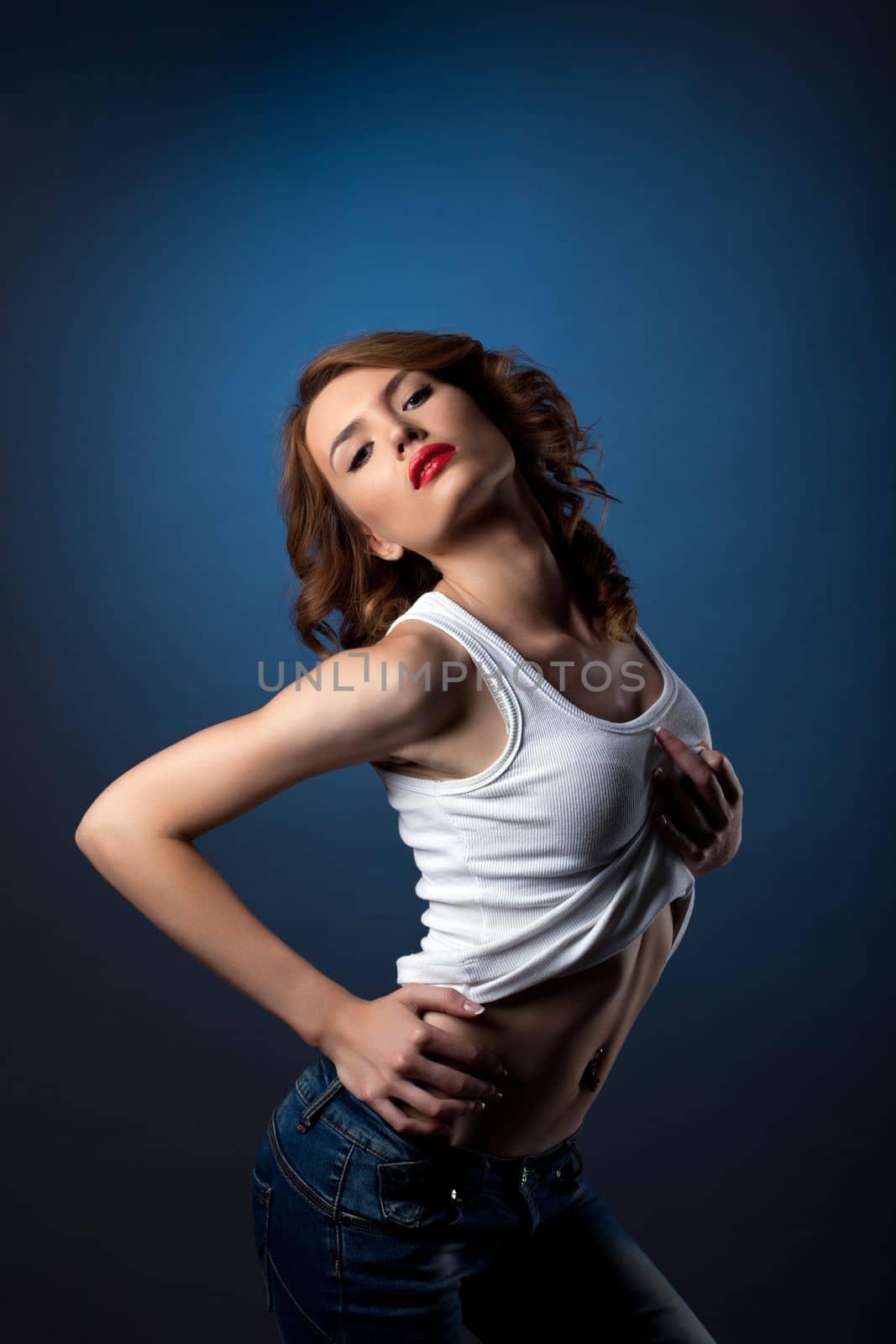 Young beautiful brunette woman in jeans and white tank top