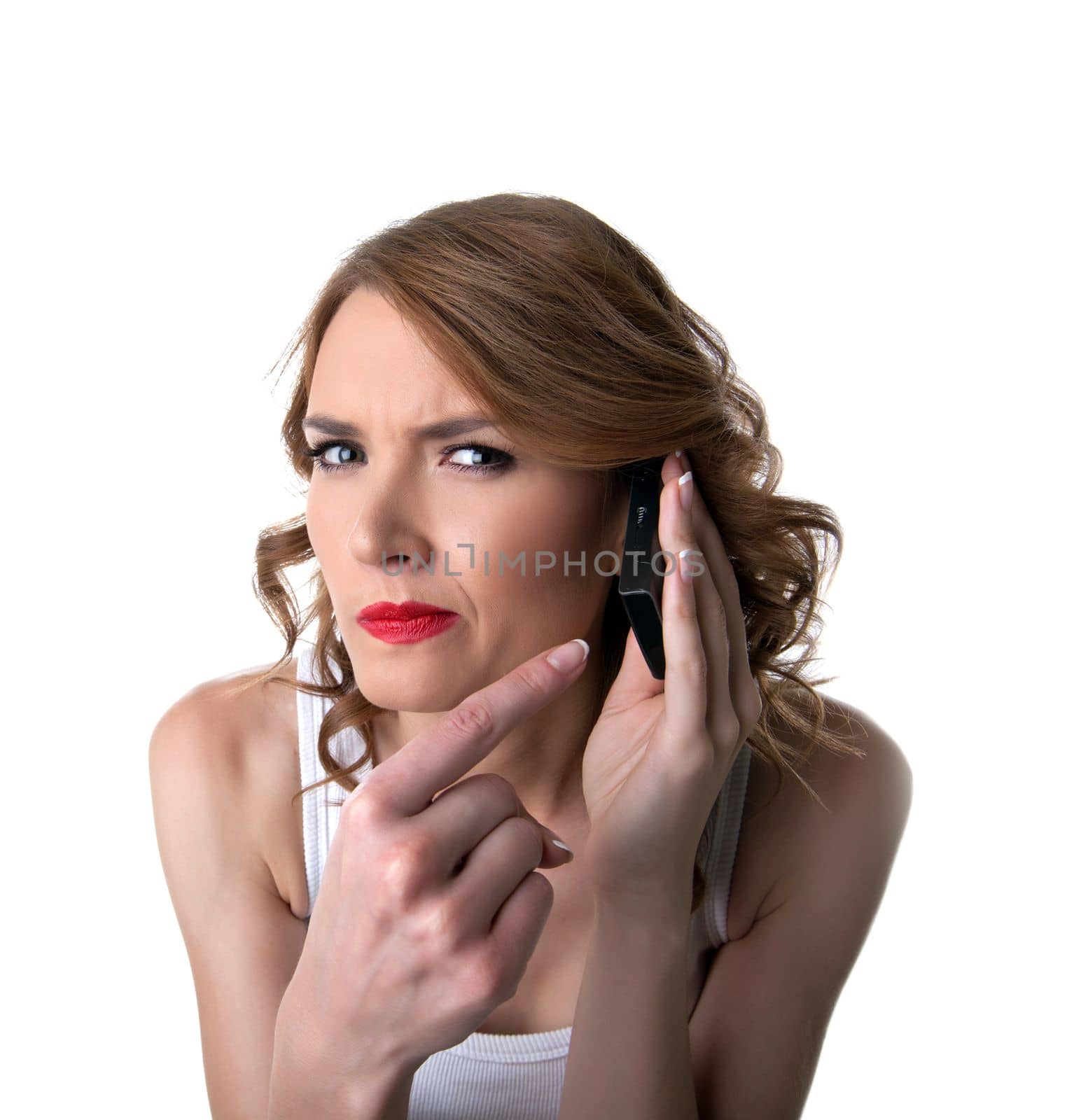 Young woman point on cell phone with suspicious emotion isolated