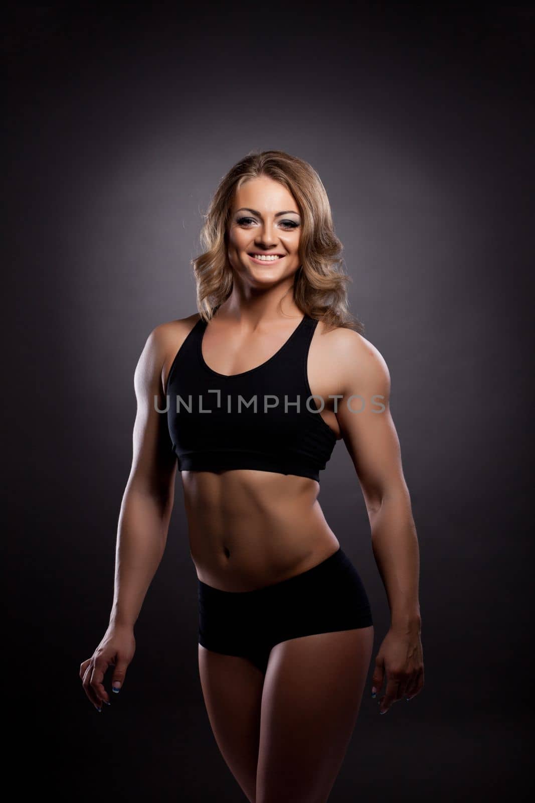 Young athletic woman body builder portrait in fitness costume