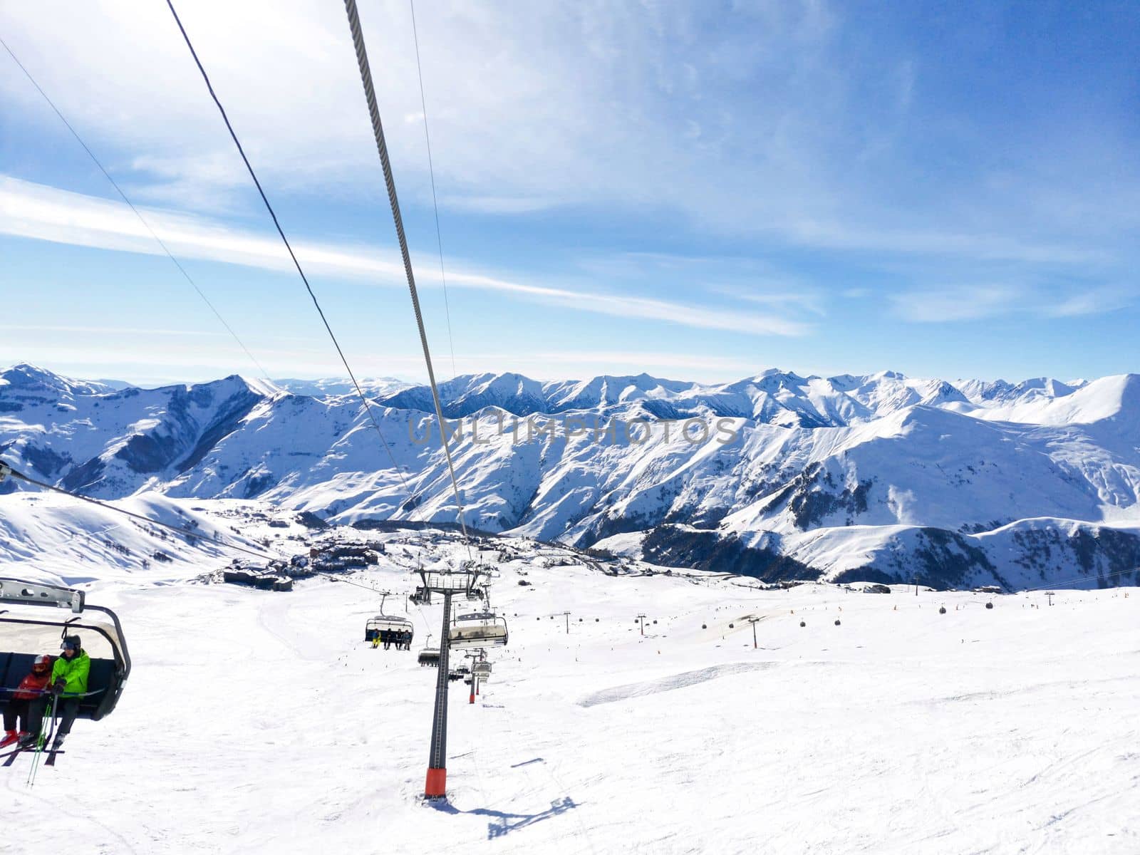 Ski resort. Mountain lift. People take lift up hill. Winter active sport. Snowcapped mountains. Georgia, Gudau