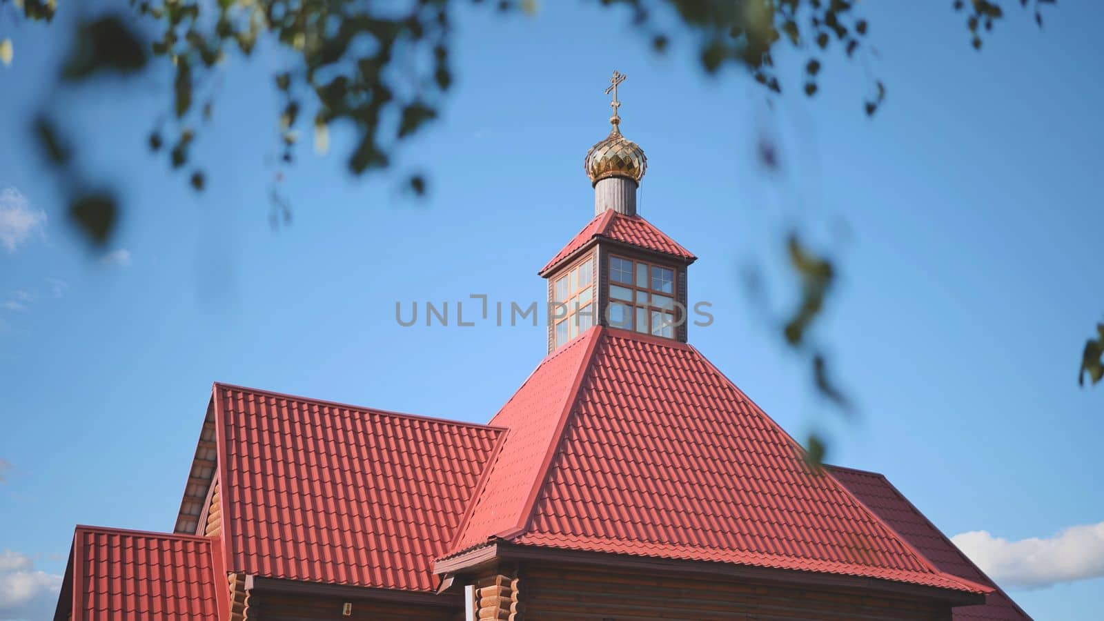 The tower of the Orthodox Church against the background of birch branches