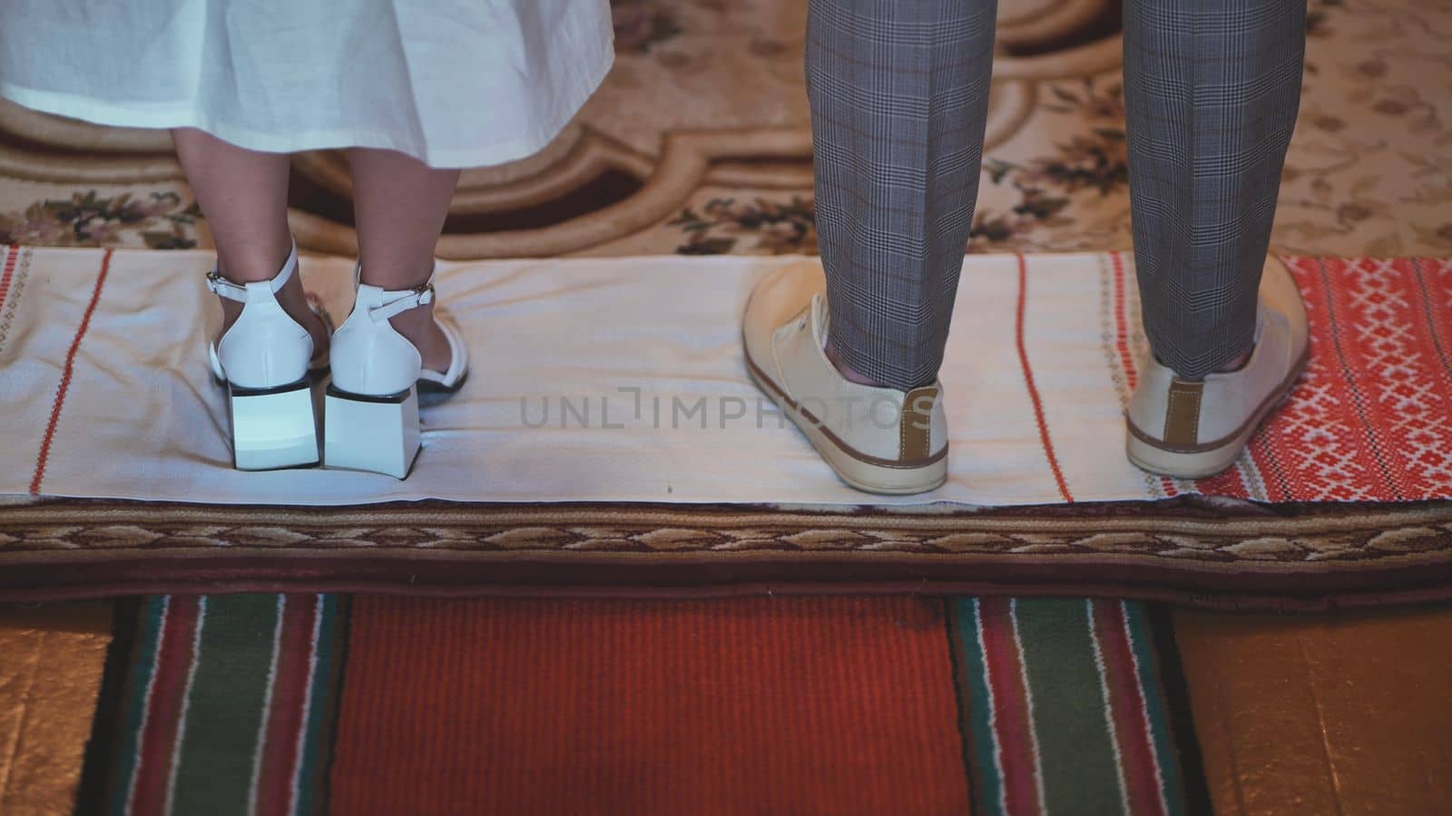 The newlyweds stand on a rushkin during the wedding ceremony. East Slavic tradition