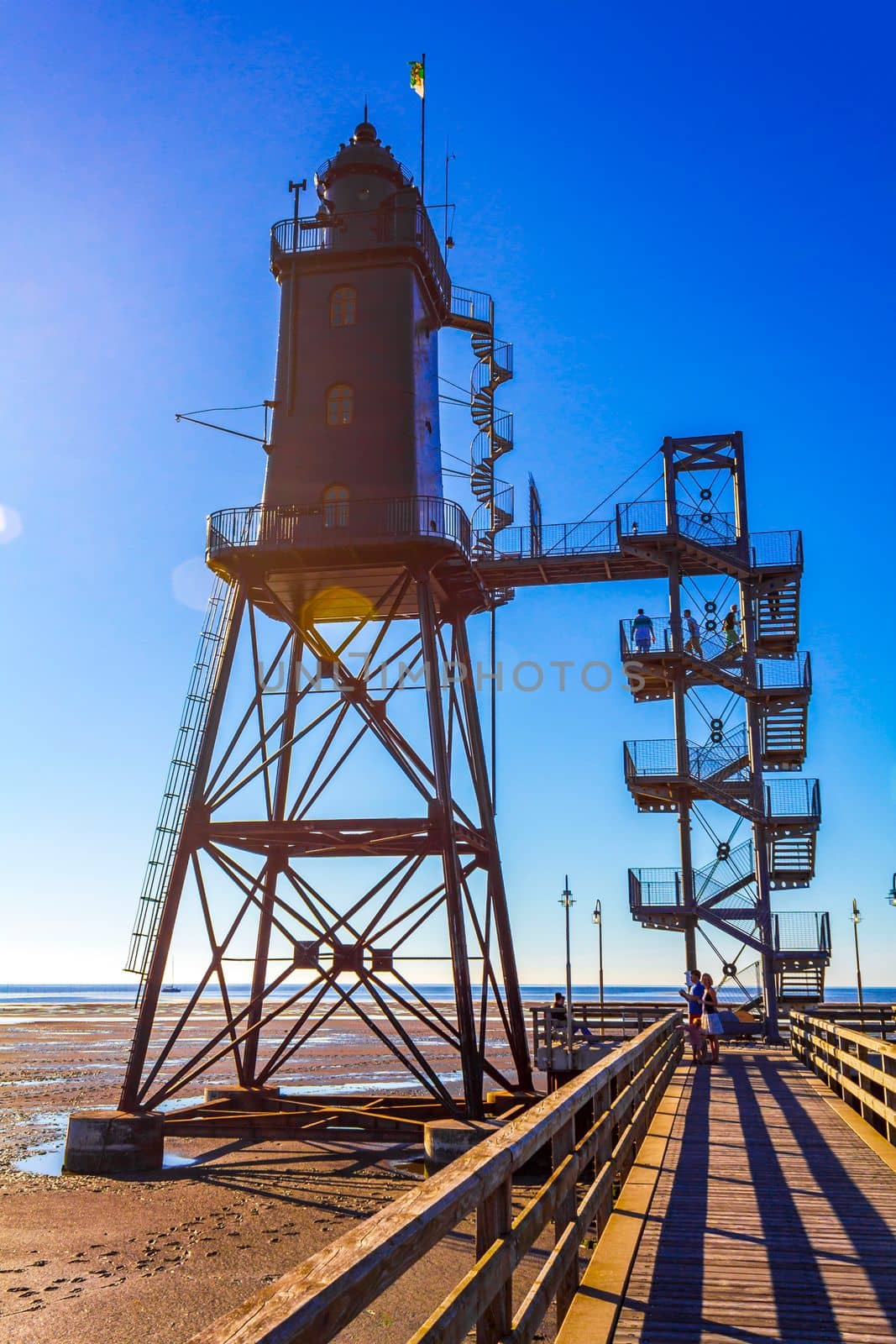 Black lighthouse tower Obererversand in Wadden Sea landscape in Dorum Wurster North Sea coast Wursten Cuxhaven Lower Saxony Germany.