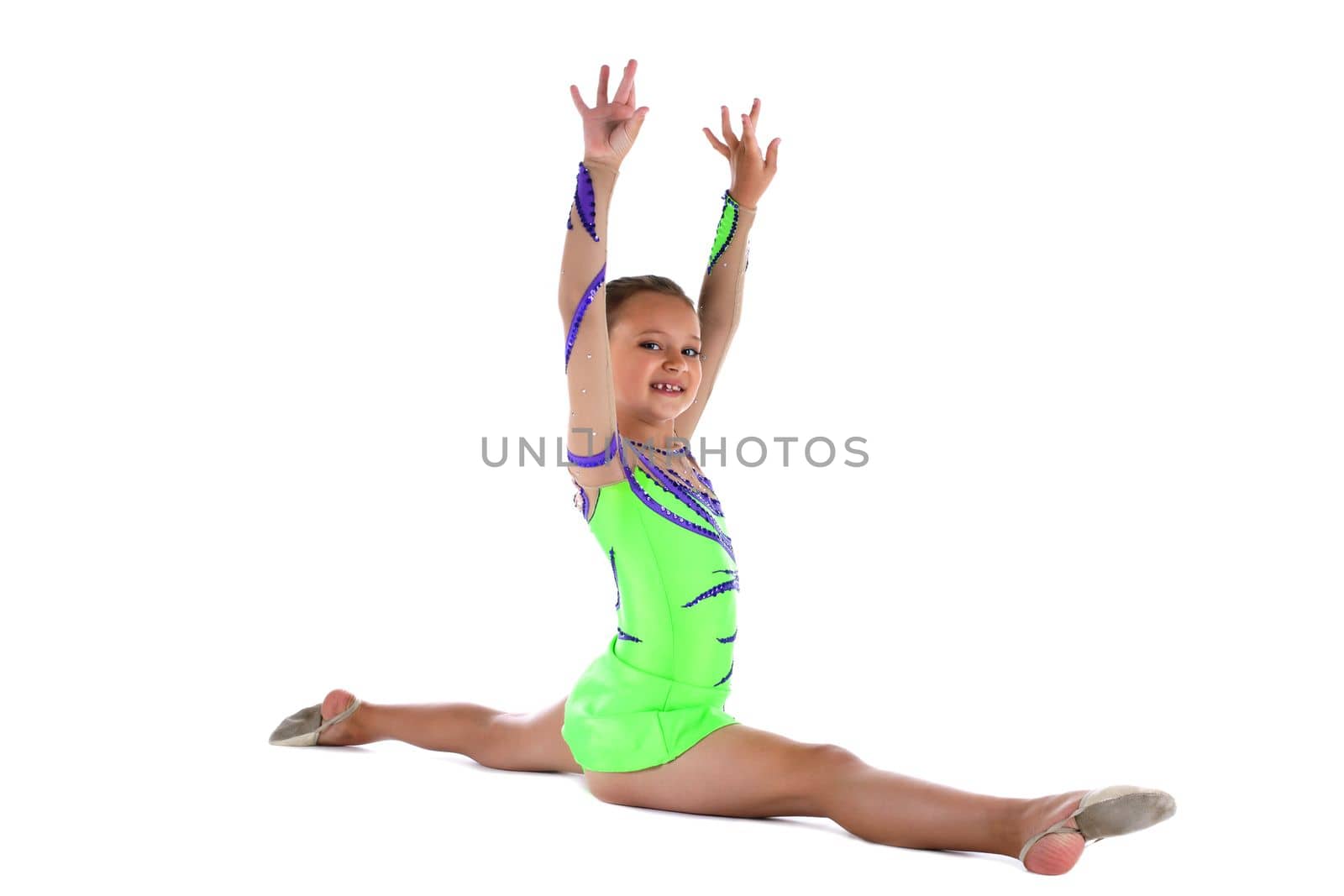 Kid gymnast doing split in green costume isolated
