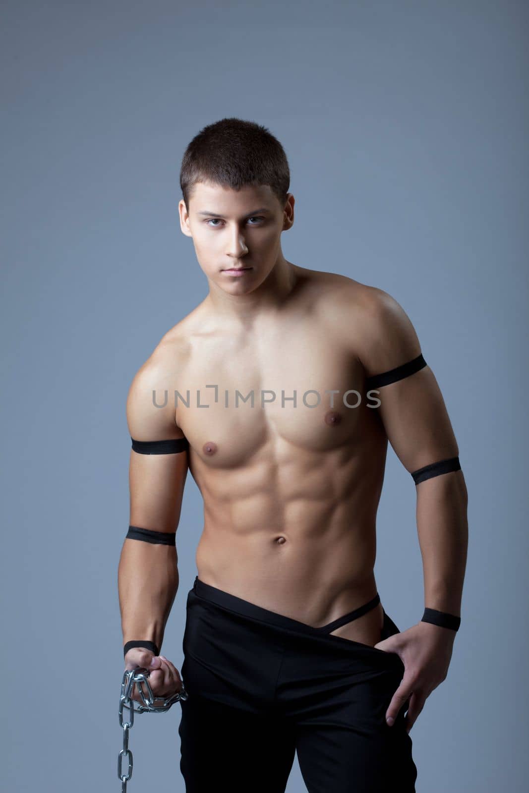 Young athletic man portrait - dance striptease with chain