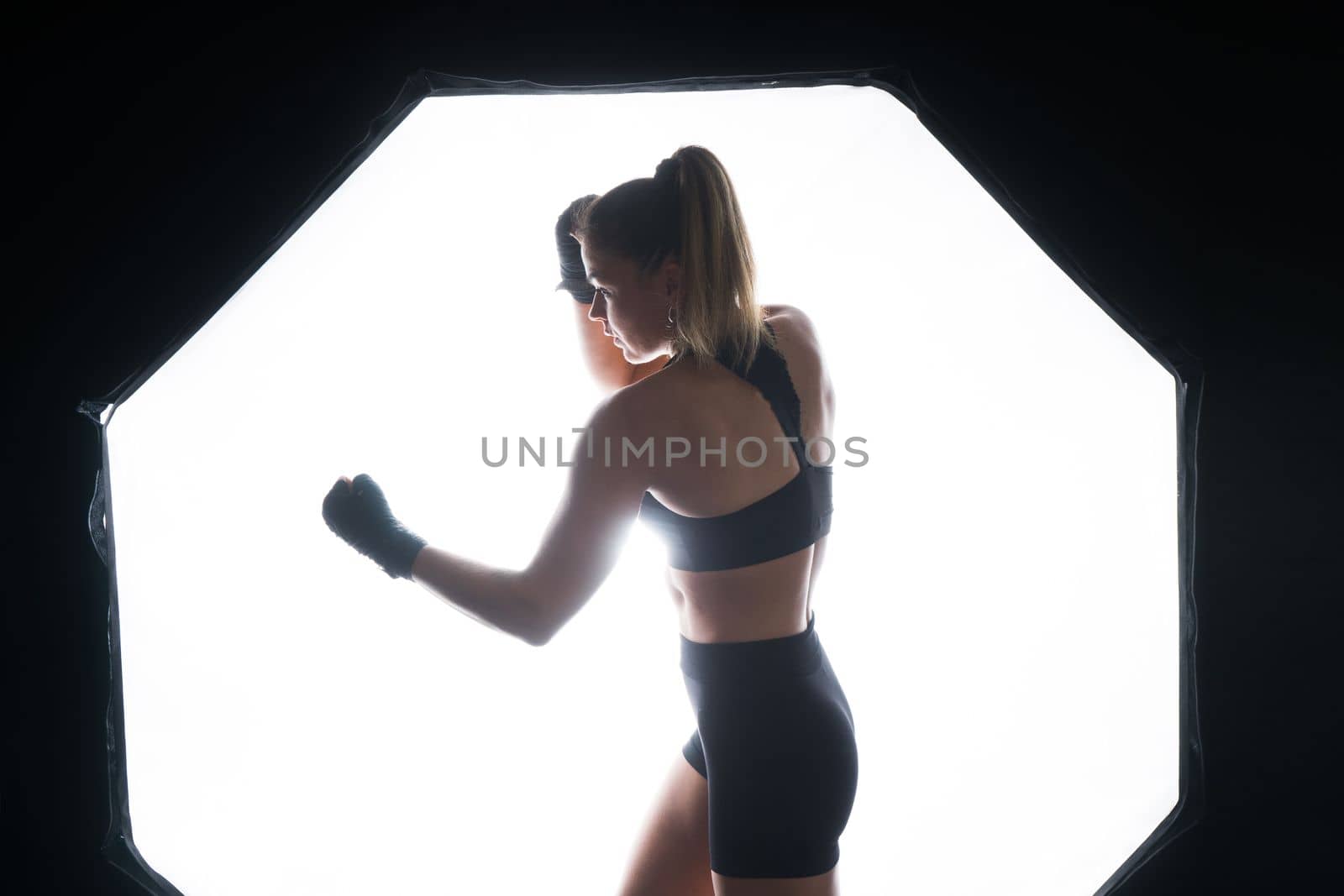 Woman Boxer In Gloves Training On a black, red, yellow Background