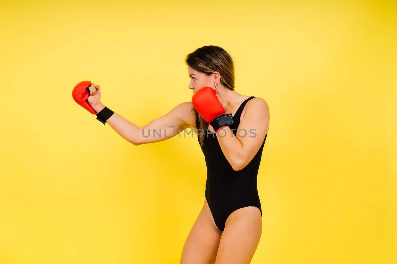 Woman Boxer In Gloves Training On black, red, yellow Background by Zelenin