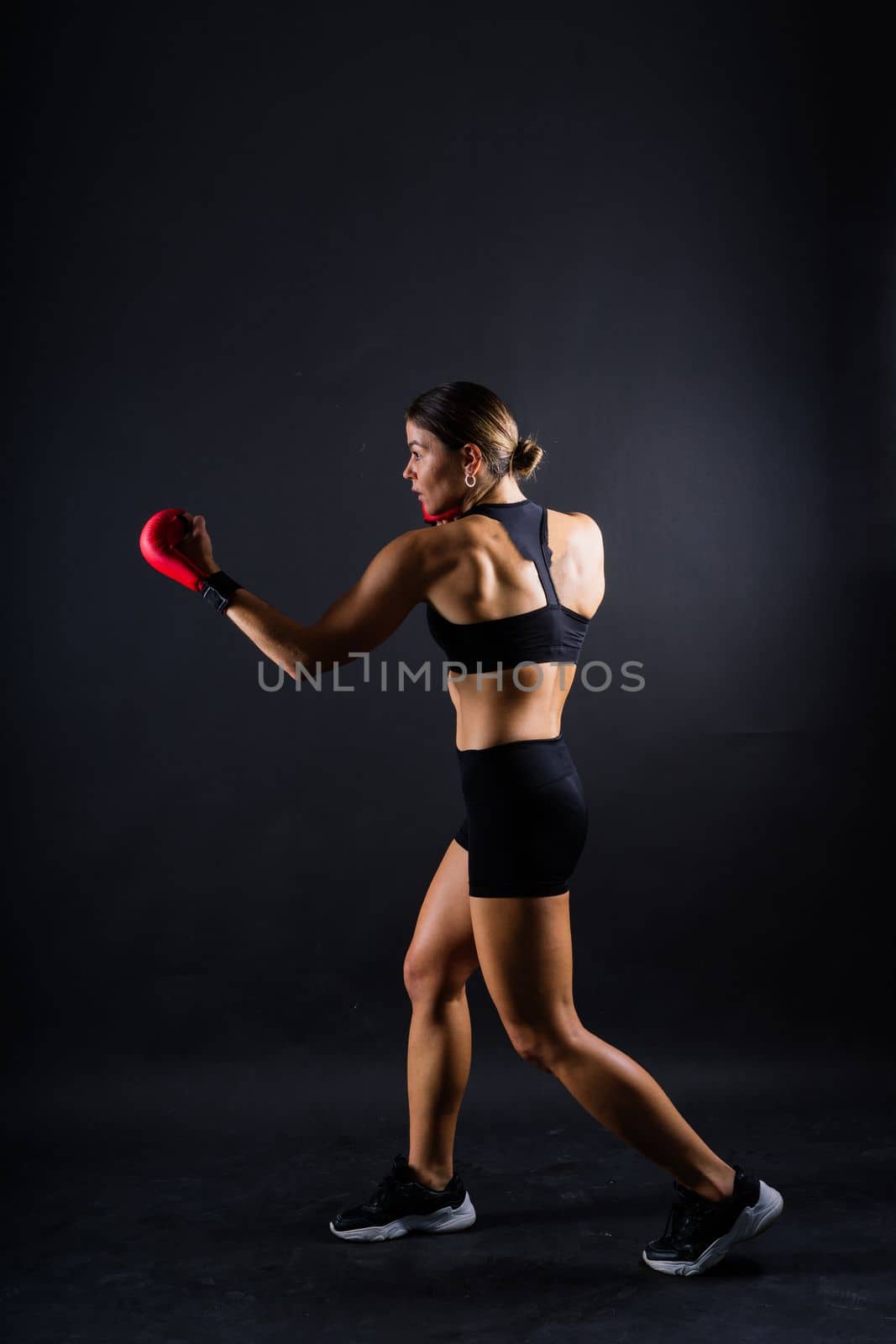 Woman Boxer In Gloves Training On black, red, yellow Background by Zelenin