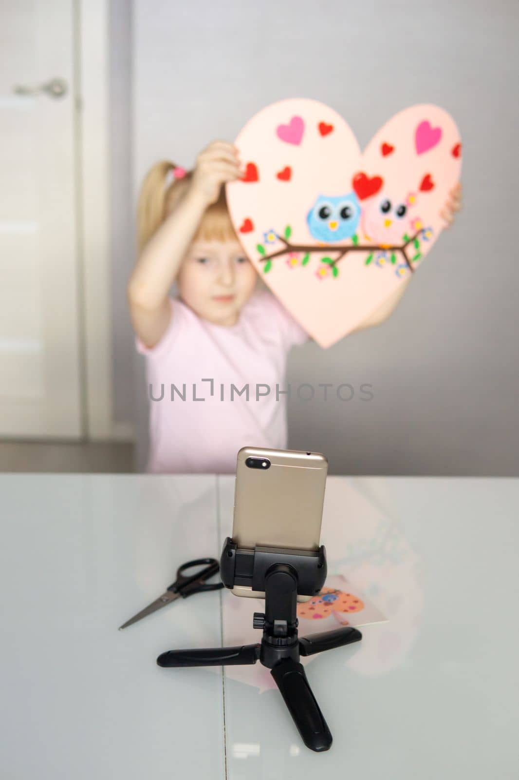 A blogger girl makes a felt craft for Valentine's Day in the shape of a heart. The concept of children's creativity and handmade. by Annu1tochka