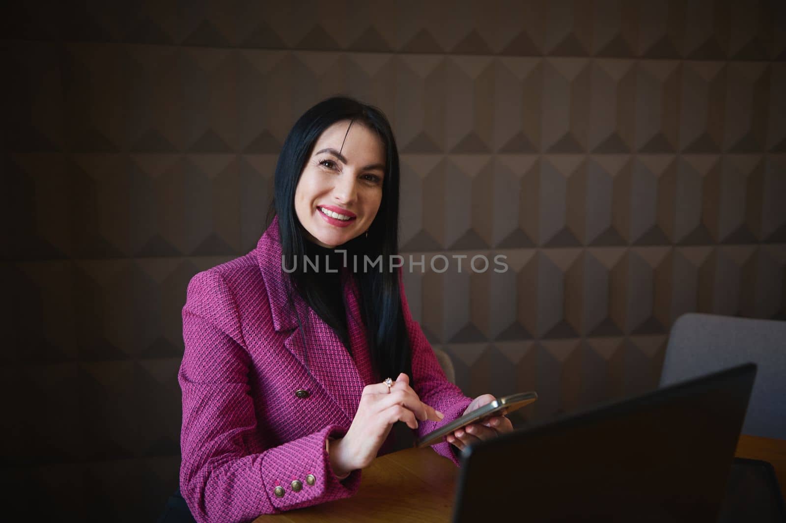 Middle-aged successful purposeful business woman at meeting in restaurant with investors or business partners. Discussion of project, advertising and promotion. Work on laptop anywhere remotely.