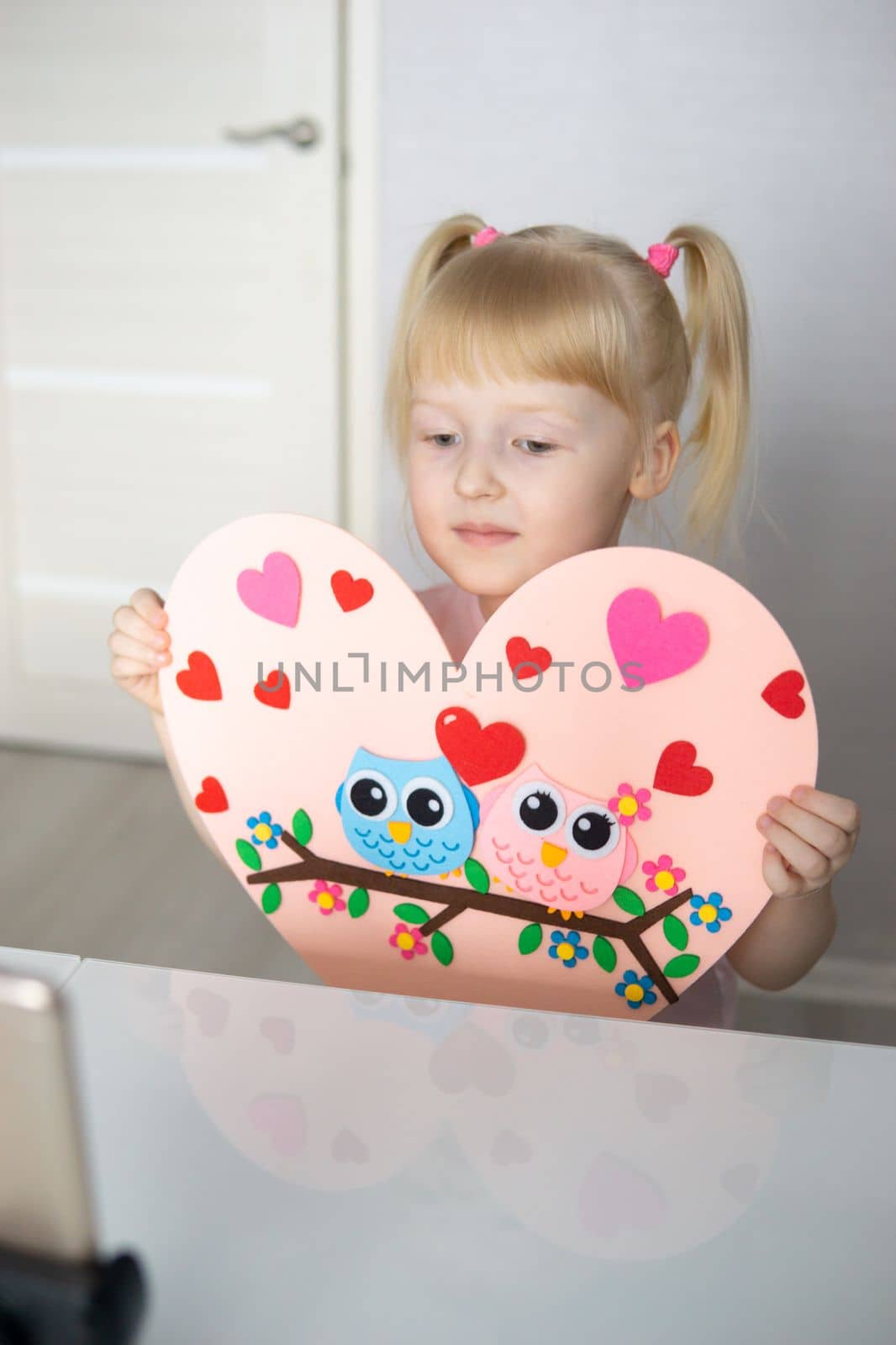 A blogger girl makes a felt craft for Valentine's Day in the shape of a heart. The concept of children's creativity and handmade. by Annu1tochka