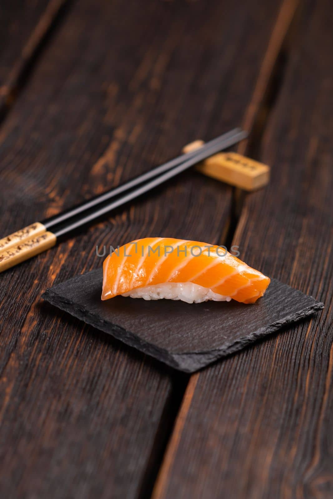 Japanese sushi food. Top view of assorted sushi nigiri with salmon on the stone natural background, vertical format