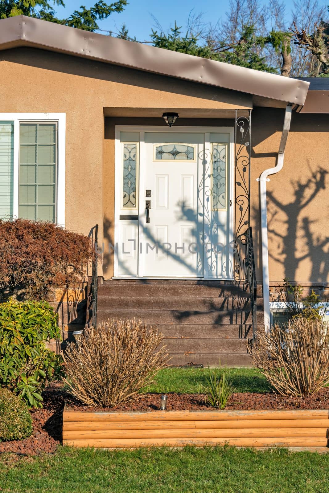 Main entrance of residential house with doorsteps on sunny day in winter