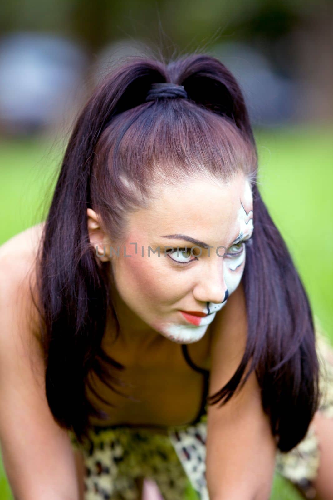 woman with face art on grass close up