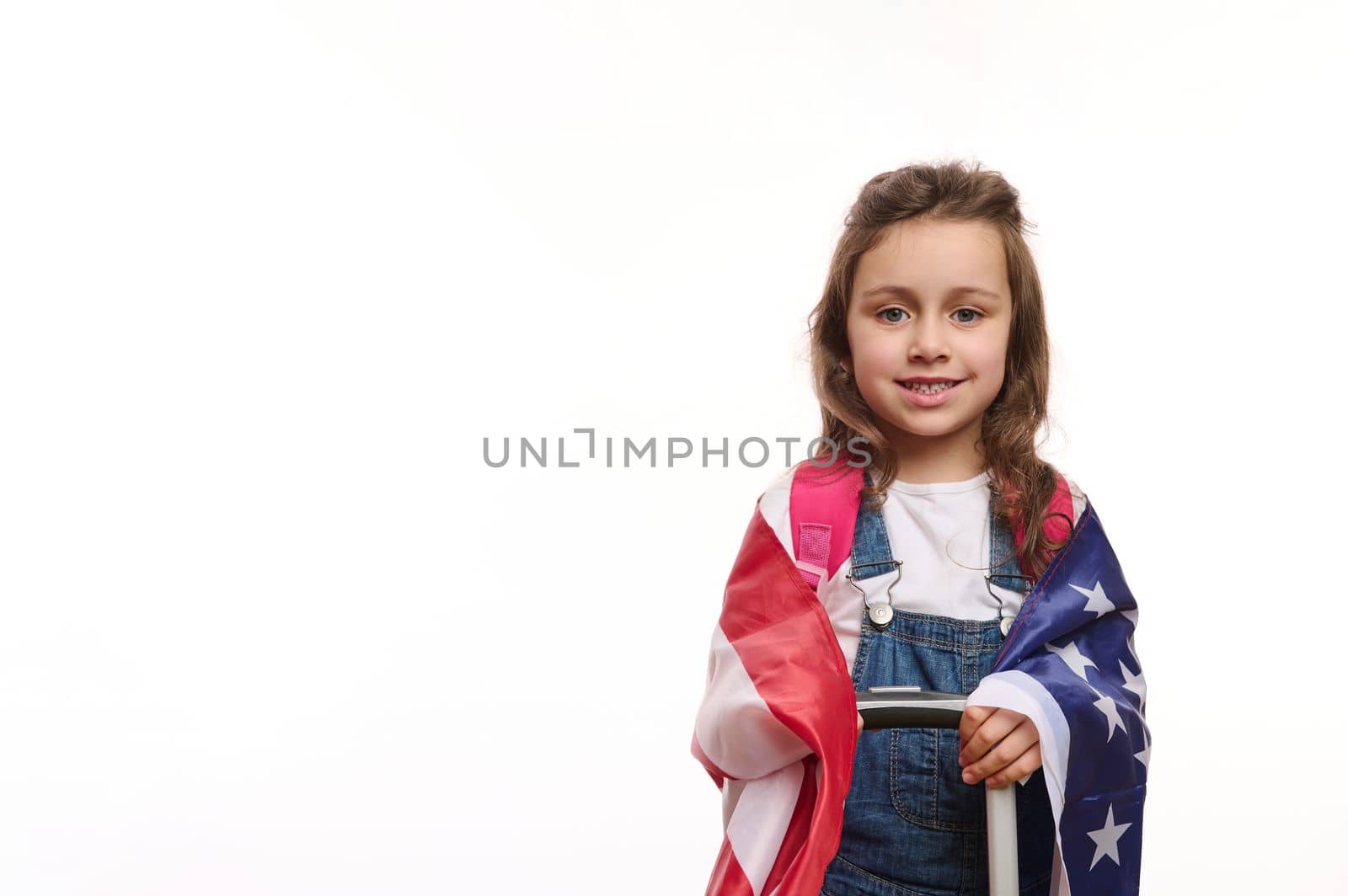 American citizen, little girl with US flag and suitcase, isolated over white background with ad space for your promotional text. English language courses. Study in America. Winning green card lottery
