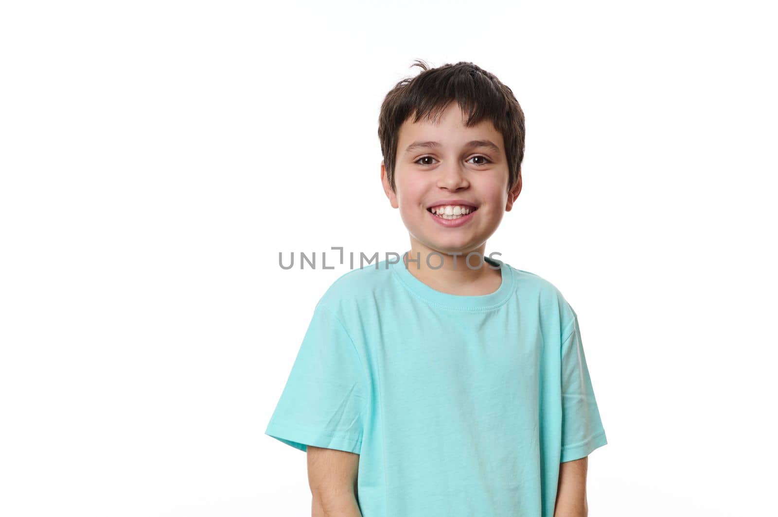 Emotional portrait of lovely Caucasian teen boy, smiling looking at camera, isolated on white background with free advertising space for your promotion. Smart schoolboy, teenager, pre-adolescent boy