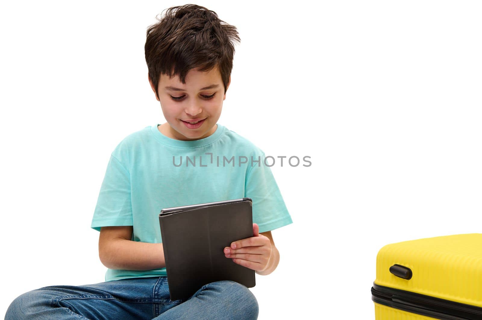 Isolated on white handsome teenage traveler boy using digital tablet, browsing websites, checking flight information by artgf