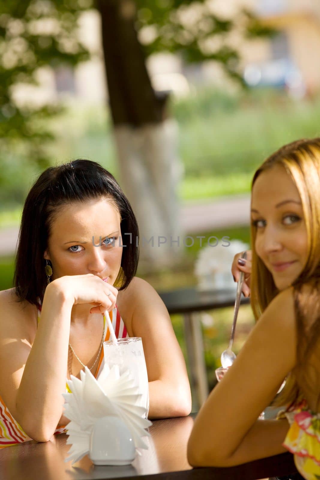 Two girl in cafe talk about