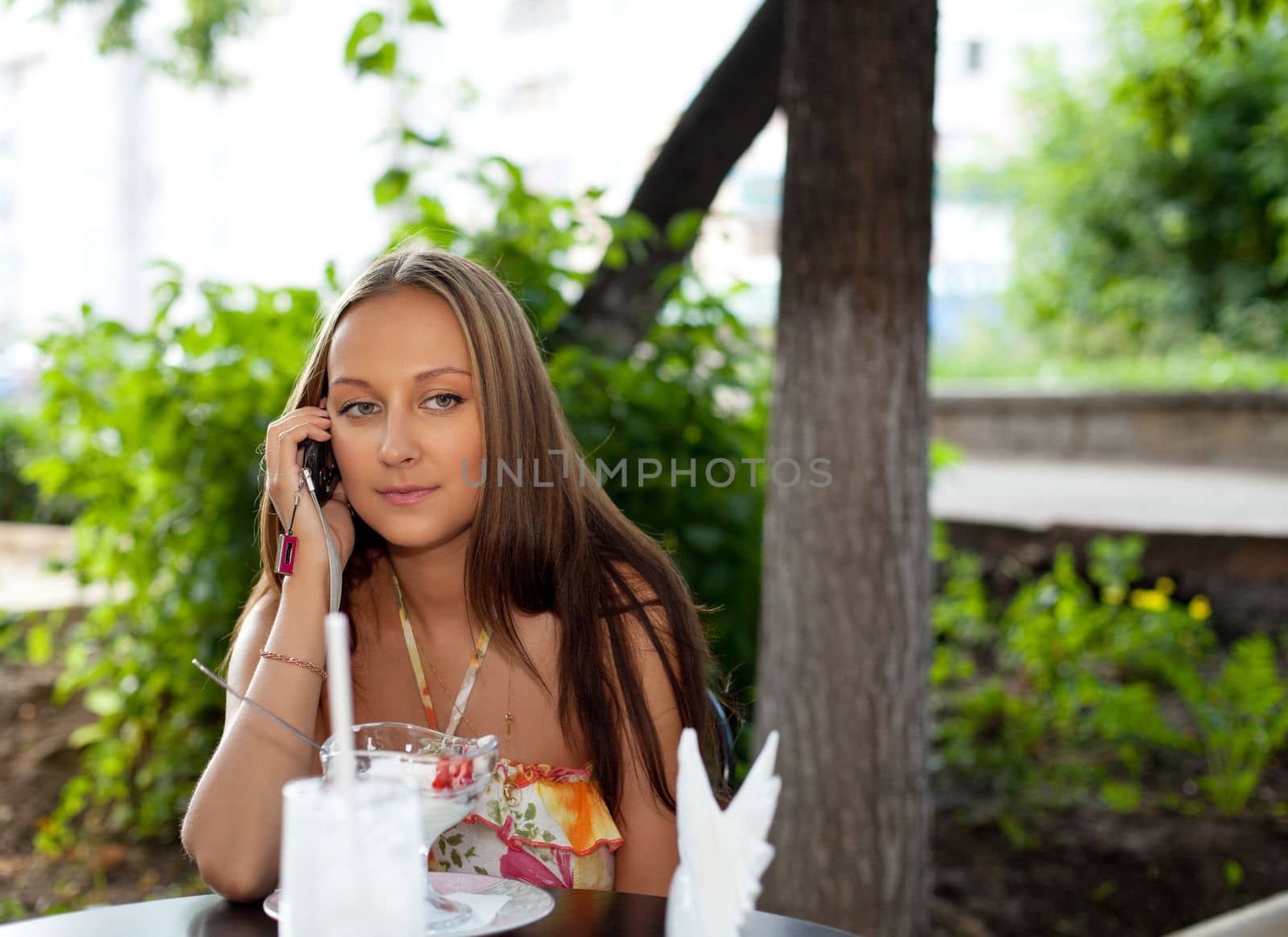 Beauty woman in summer cafe talk a phone by rivertime