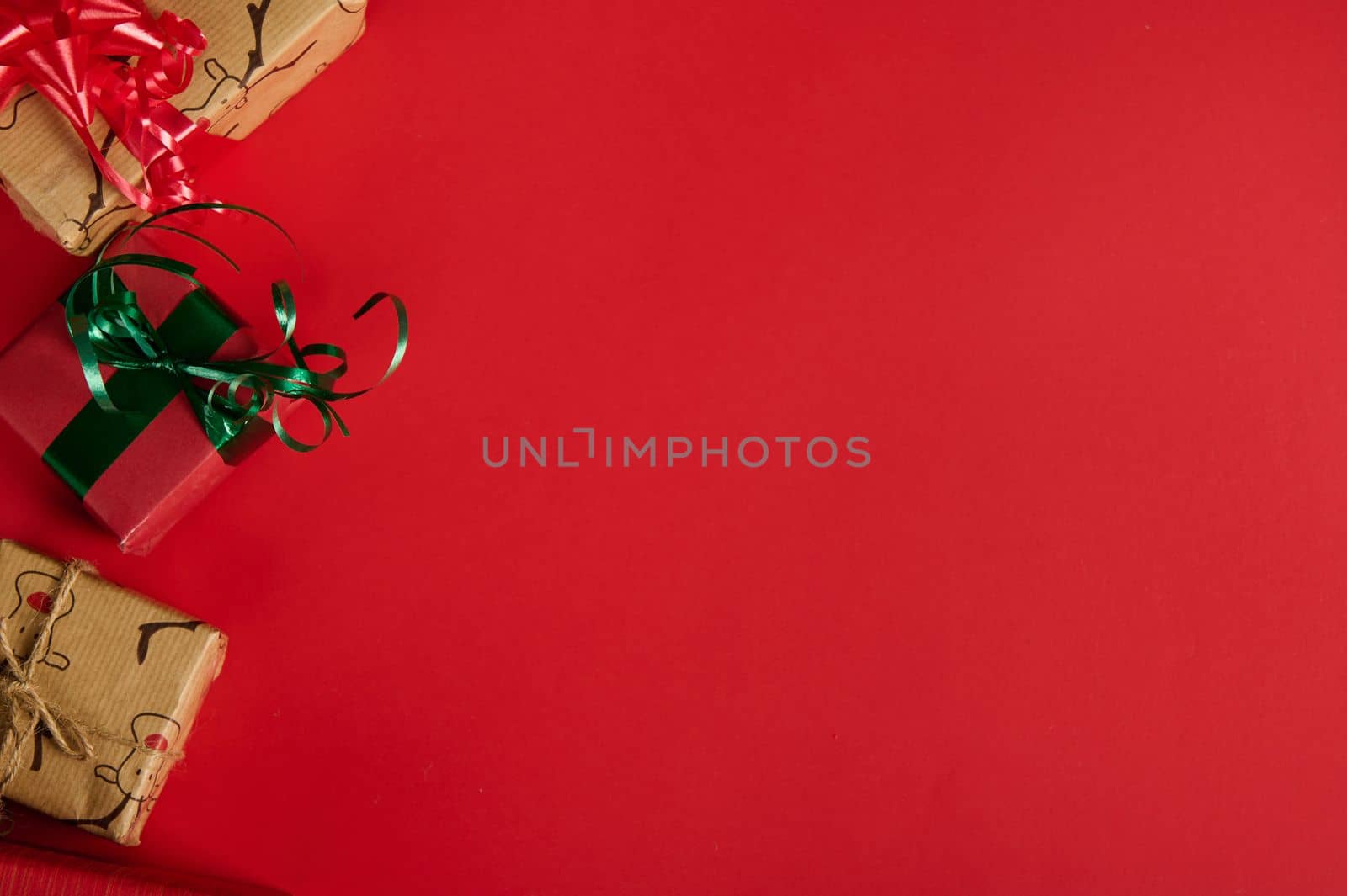 Christmas still life with gifts in the corner of a red background. Copy ad space. Mockup, layout for promotional text. Boxing Day. Xmas and New Year's preparations. Packing gifts. Web banner. Flat lay