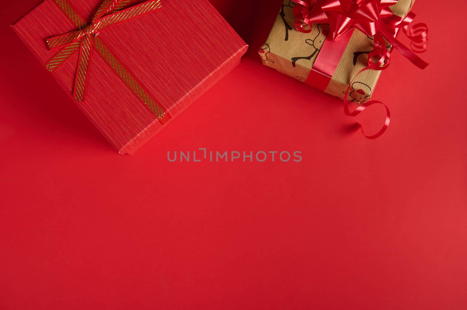 Beautiful cute Christmas gifts in the top of red background with copy advertising space. Mockup for New Year's promotional text. Packing presents for Xmas and any other celebration events. Boxing Day