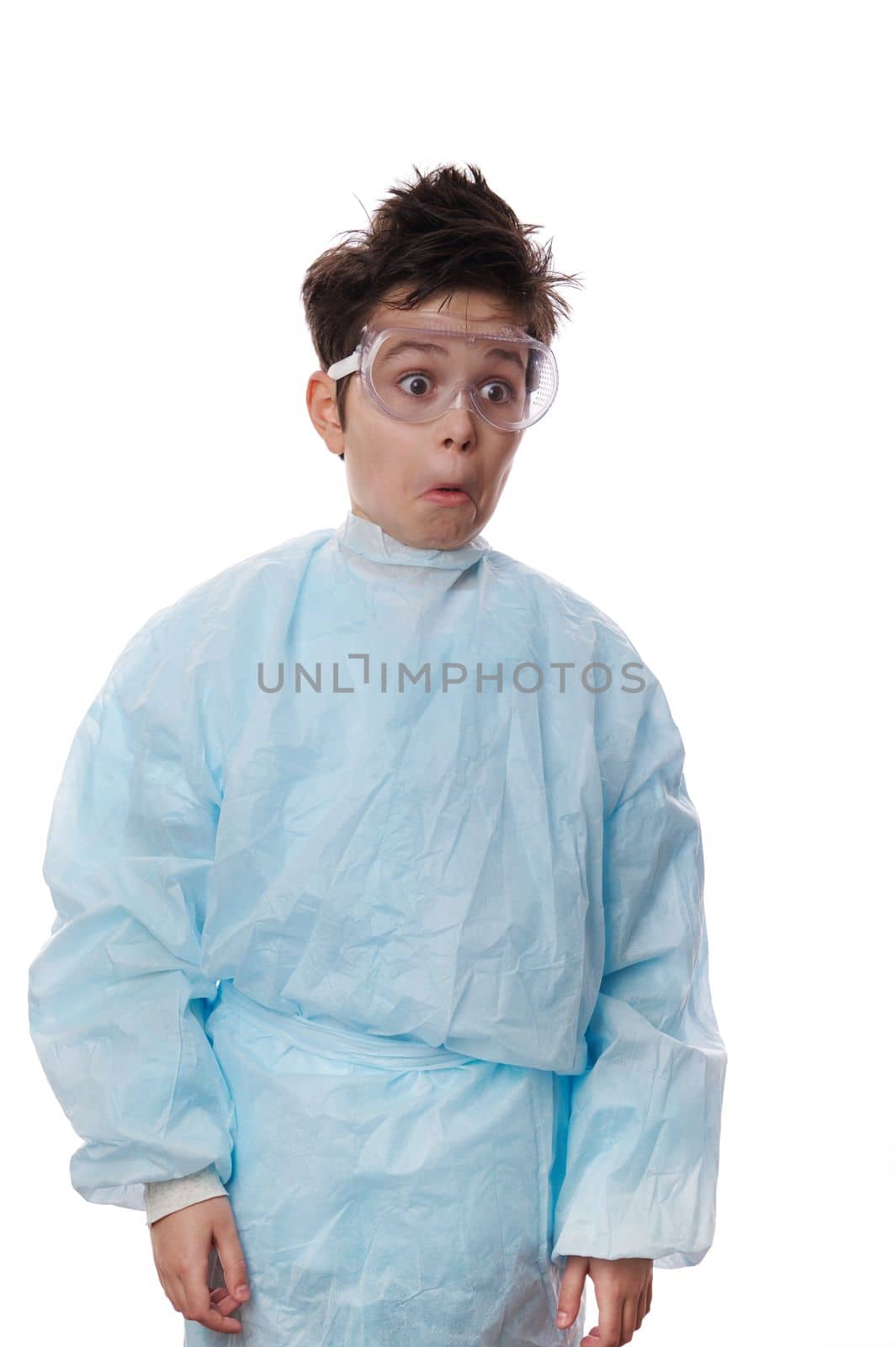 Waist-length emotional portrait on white background of a nerd school kid, stupefied shocked Caucasian teenage boy, young chemist scientist wearing lab coat and safety goggles, expressing astonishment