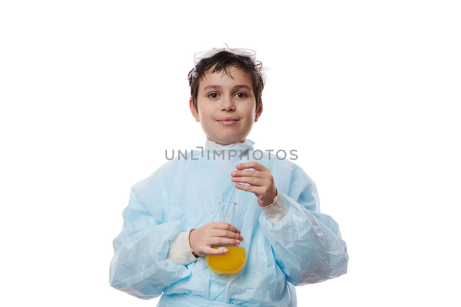 Confident portrait on white background of school kid, a smart teenage boy, young chemist scientist biologist in lab coat, holding a glass flask with chemicals and smiling looking at camera. Chemistry