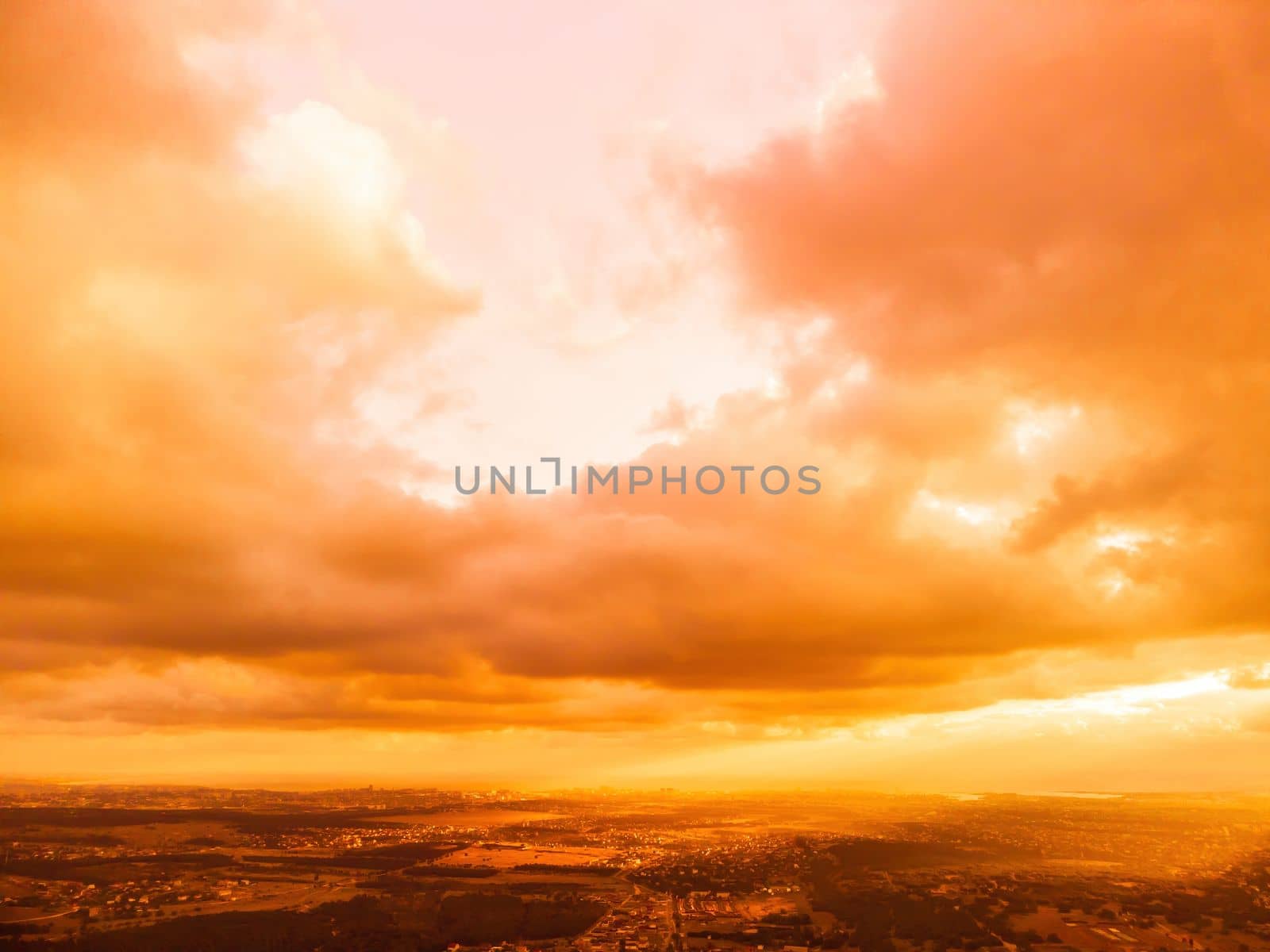 Aerial view red burning sunset over the sea with rocky volcanic cliff. Abstract nature summer sunset ocean sea background. Small waves on golden warm water surface Evening. Horizon. Nobody. No people. by panophotograph